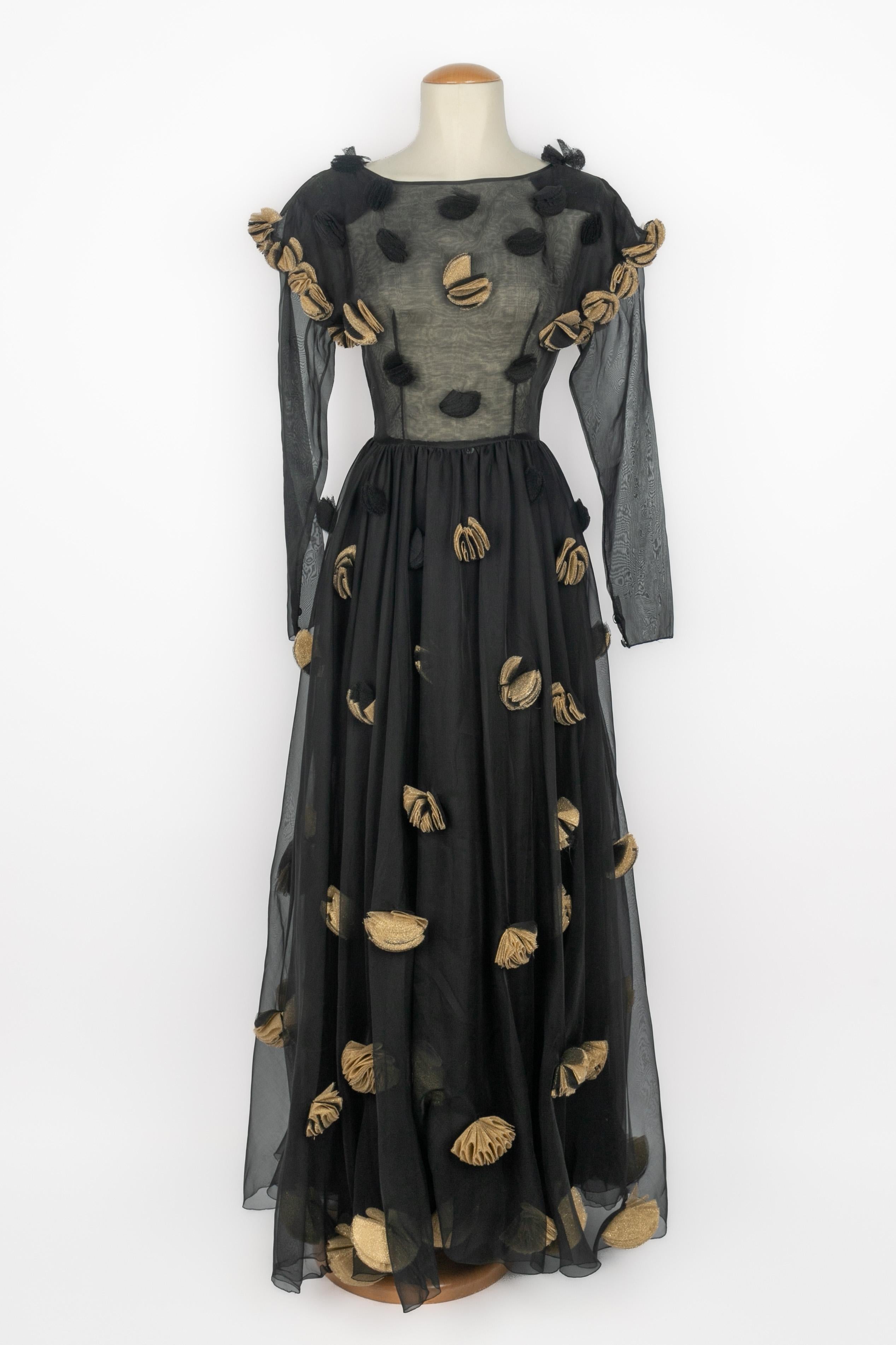 CHLOÉ - (Made in France) Goldenes und schwarzes Abendkleid aus Musselin. Rundhalsausschnitt und Volant-Effekt an den Schultern. Das Kleid ist mit goldenen und schwarzen Blütenblättern verziert. Zusammensetzung und Größe Etiketten fehlen, es passt