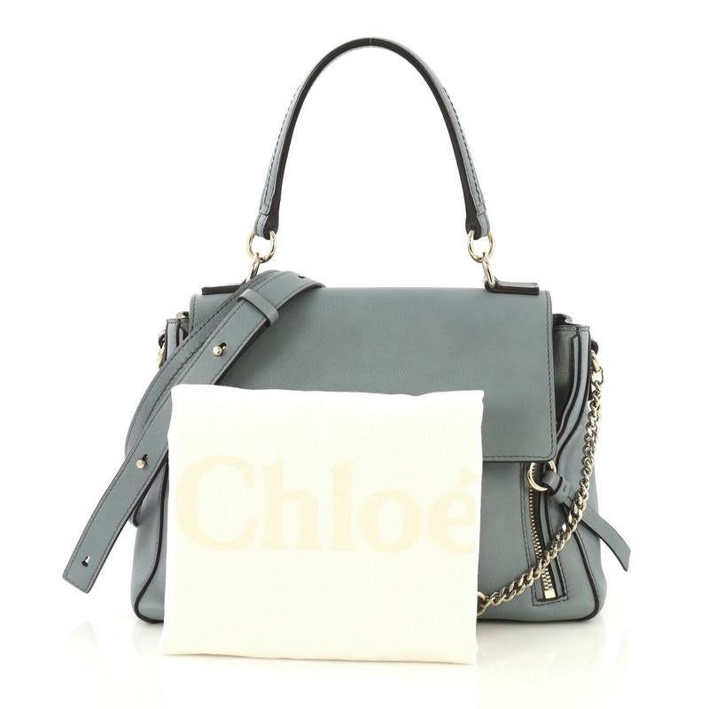 This Chloe Faye Day Bag Leather Small, crafted from blue leather, features a leather top handle, flap top with chain-clip and ring detail, dual side zips that expand bag, and gold-tone hardware. It opens to a beige fabric interior divided into two