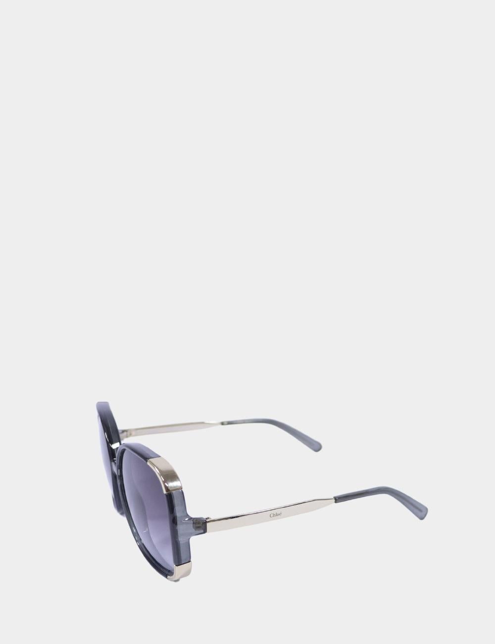 Eleganza senza sforzo con questi occhiali da sole quadrati oversize di Chloé, caratterizzati da morbide lenti sfumate e bordi arrotondati chic. La montatura grigio fumo è rifinita con sottili accenti dorati sulle aste, che riflettono l'estetica