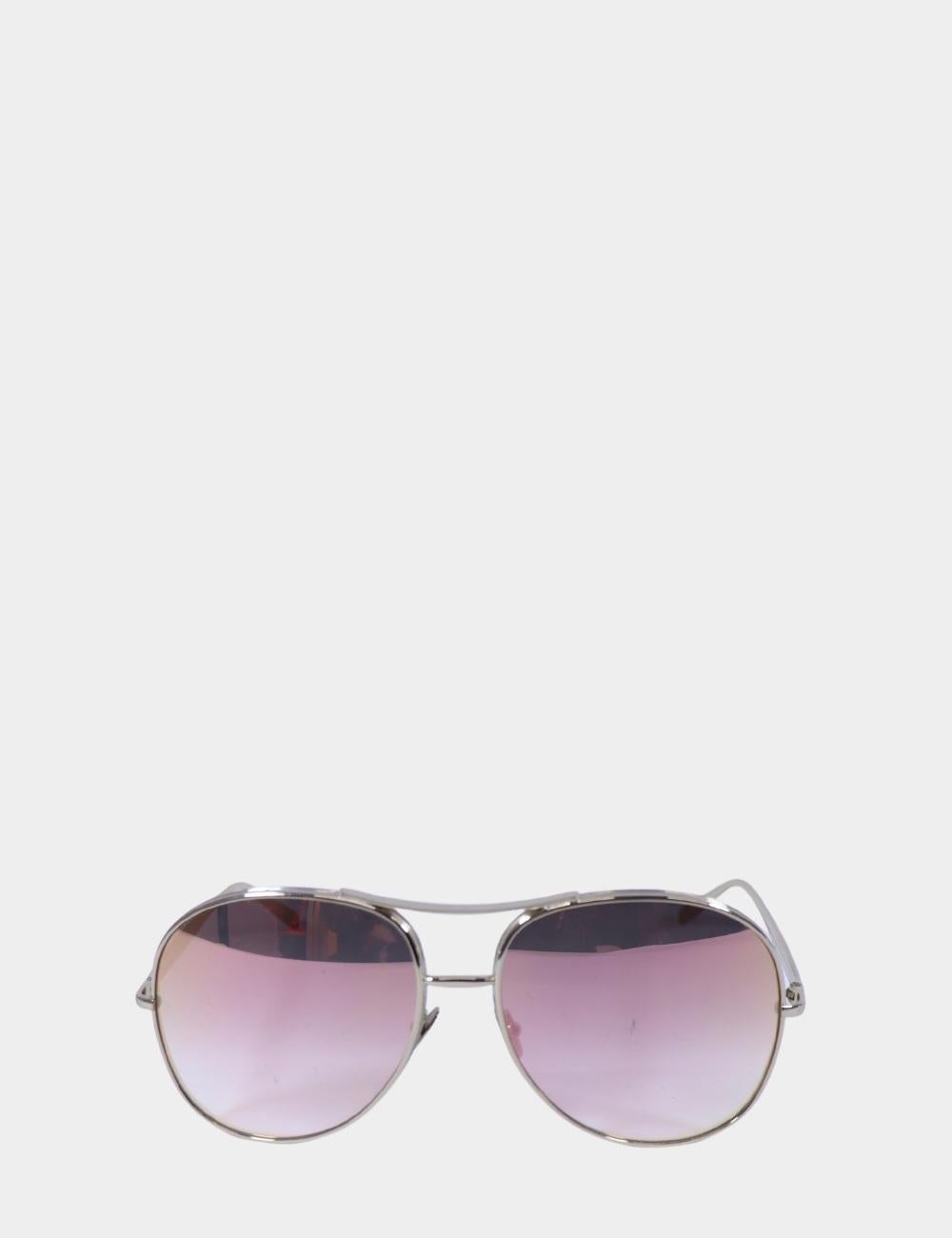 Delicati ma audaci, questi occhiali da sole aviator di Chloé presentano una montatura leggera in metallo argentato e lenti sfumate rosa da sogno. Una rivisitazione moderna di una silhouette senza tempo, questa coppia aggiunge un tocco morbido e