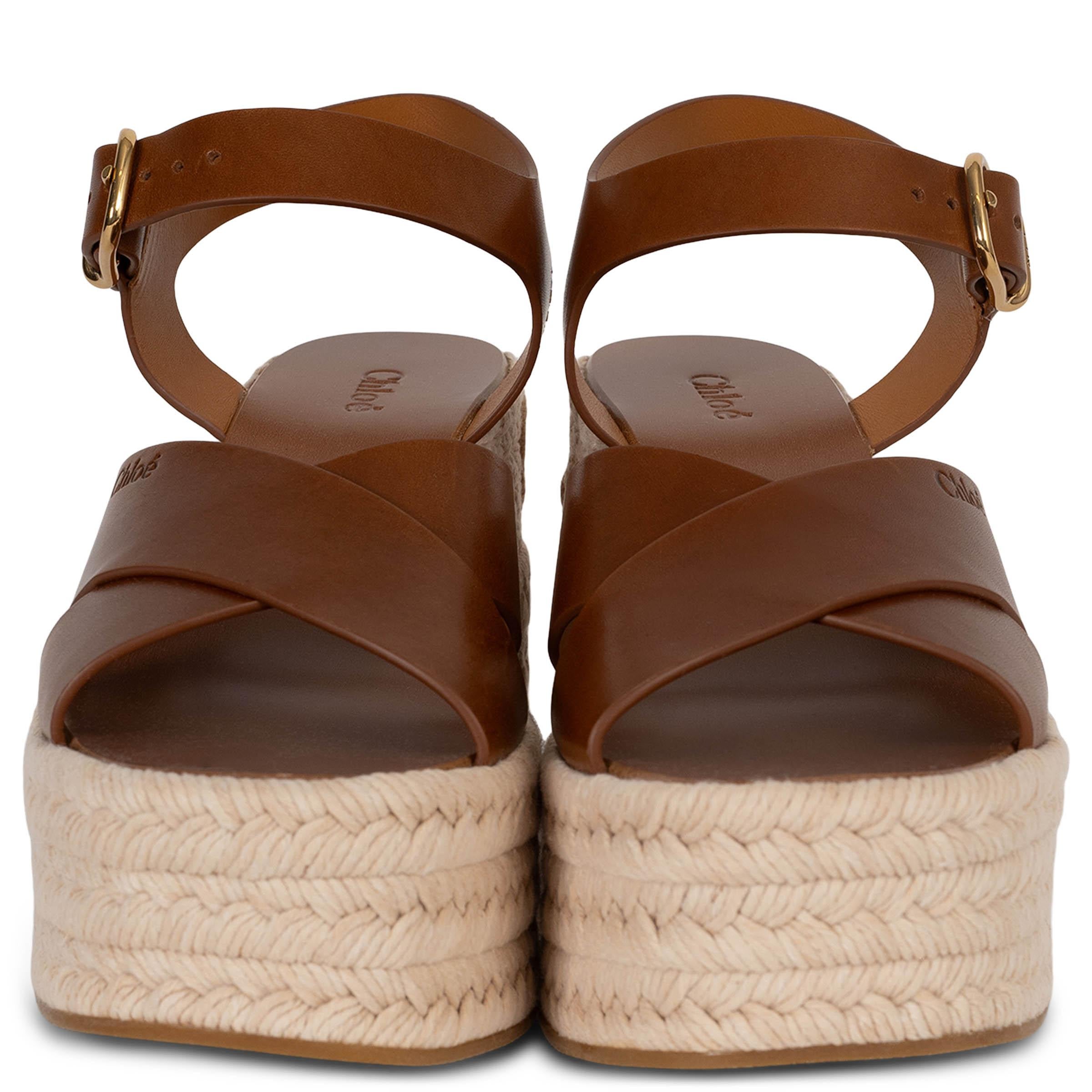 Estas sandalias Chloé Isla 100% auténticas de piel de becerro marrón jengibre tienen tiras cruzadas en la parte delantera con un discreto logotipo grabado y una tira ajustable en el tobillo. Asentadas sobre una suela de cuña de alpargata de cordón