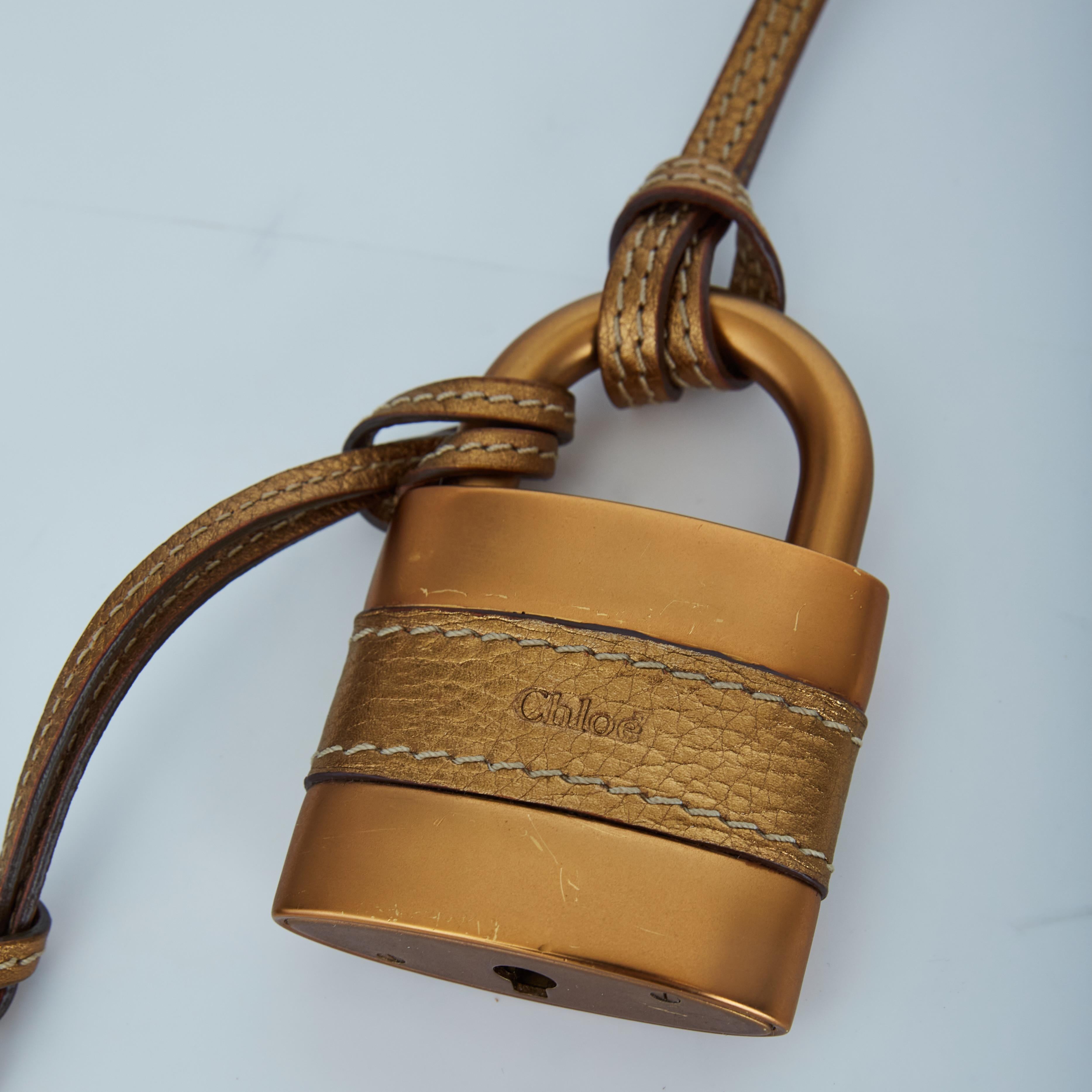 Color: Gold tone
Material: Metal and leather
Measurements: Length 2” x Width 3.5” (Padlock)
Comes with: Box
Condition: Very good: looks never used with faint hairline scratches throughout.
