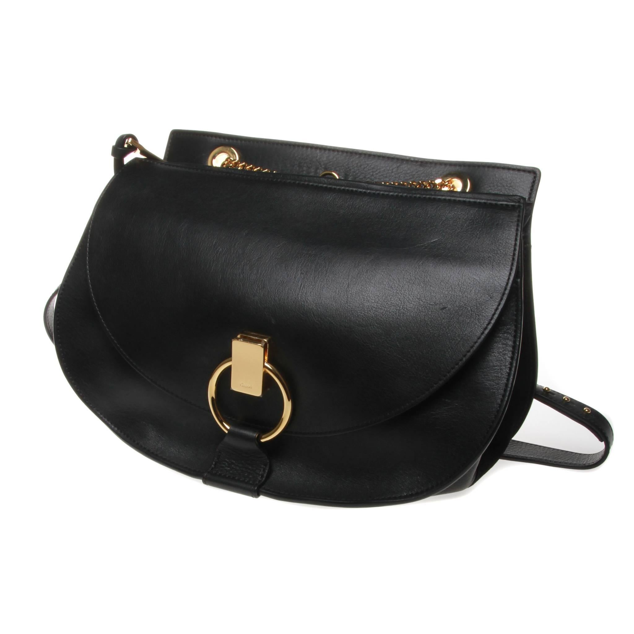 Chloe 'Goldie' shoulder bag in black calf leather and suede with gold-tone hardware. In a covetable shape inspired by the saddle, this bag features a main compartment with zipped top closure, a front flap pocket with ring and clasp fastening and an