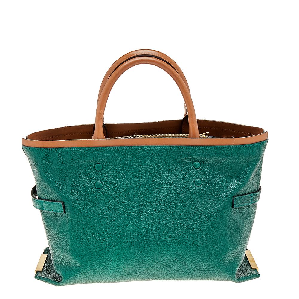 This Chloé Charlotte tote has been crafted from green & brown leather and features dual rolled handles. The tote is styled with gold metal side plates with twist locks on each side. It has a wide top, opening to a leather interior that houses two