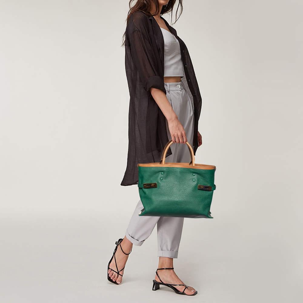 This Chloé Charlotte tote has been crafted from green & brown leather and features dual rolled handles. The tote is styled with gold metal side plates with twist locks on each side. It has a wide top, opening to a leather interior that houses two