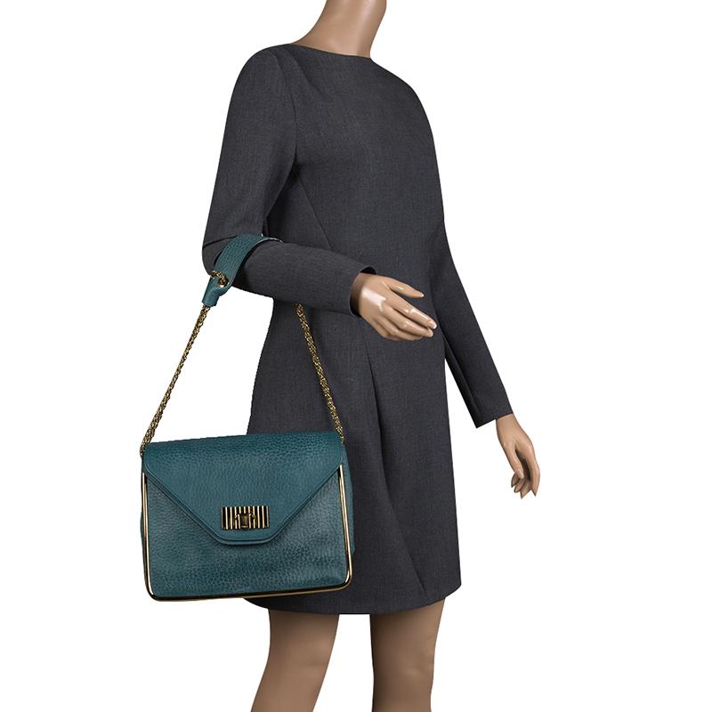 This Sally bag from Chloe is beautifully crafted in leather flaunting a green hue. The flap features a twist lock closure in gold-tone hardware that opens to a fabric-lined interior with zipped pocket. The bag offers durability owing to the metal