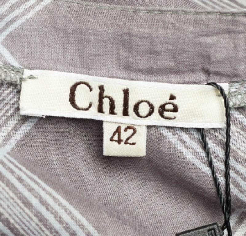 Verleihen Sie Ihrem Look mit dieser Bluse von Chloe ein Element von Stil und Eleganz. Diese Bluse in Oversized-Silhouette ist aus grauem Baumwollstoff mit Karodrucken und gerüschten Formationen gefertigt. Diese Bluse wird Ihr Favorit für legere