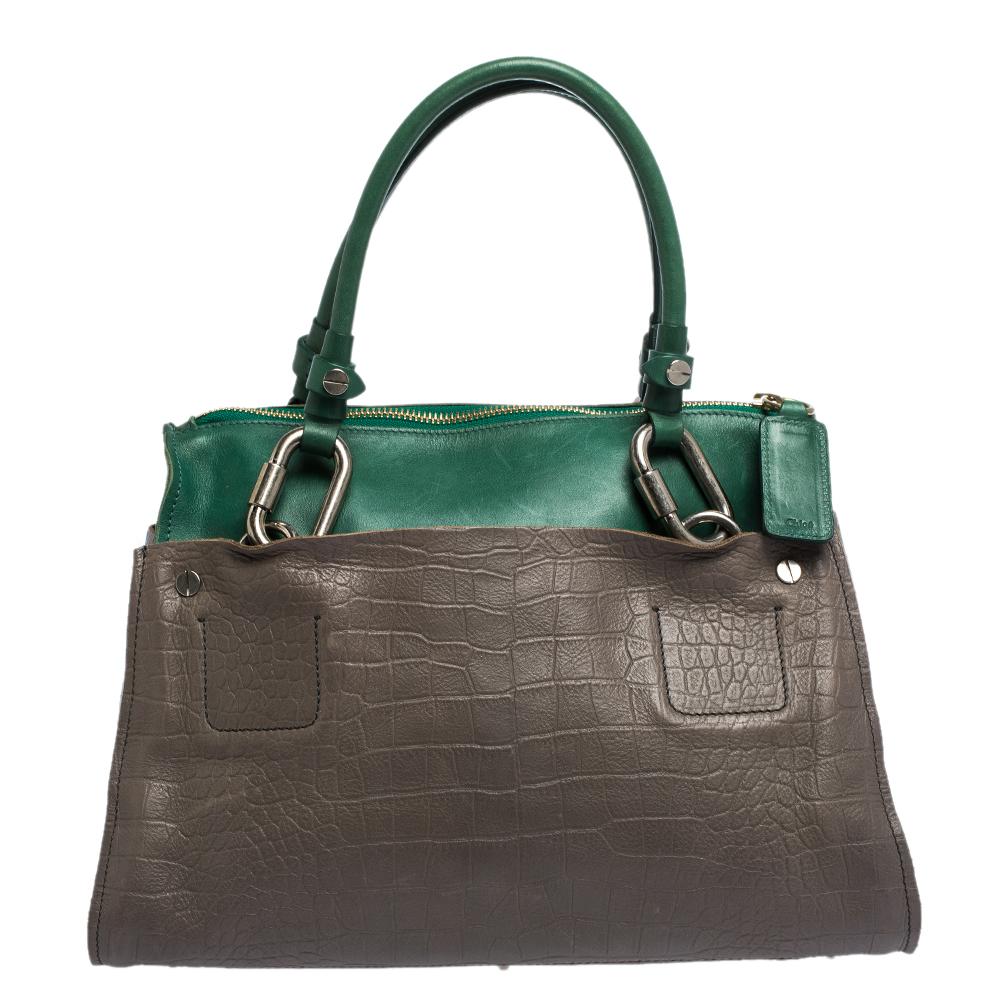 Featuring two handles attached with notable, silver-tone buckles, this Chloe tote is the kind of bag you would want to swing every day. The croc-embossed leather bag features a capacious canvas interior to house all your essentials and metal studs