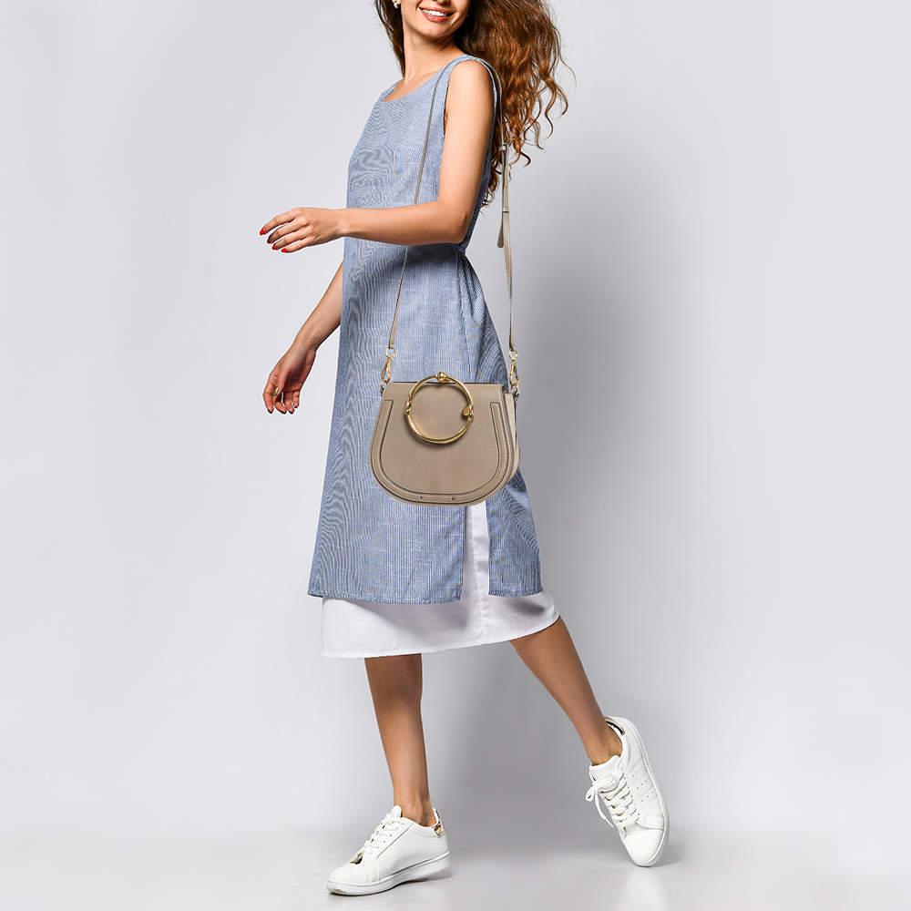 This Nile bag by Chloe can become your most favourite bag thanks to its unique shape and the bracelet handle. It has been crafted from suede along with leather and styled with a front flap that opens to a suede interior housing an open compartment