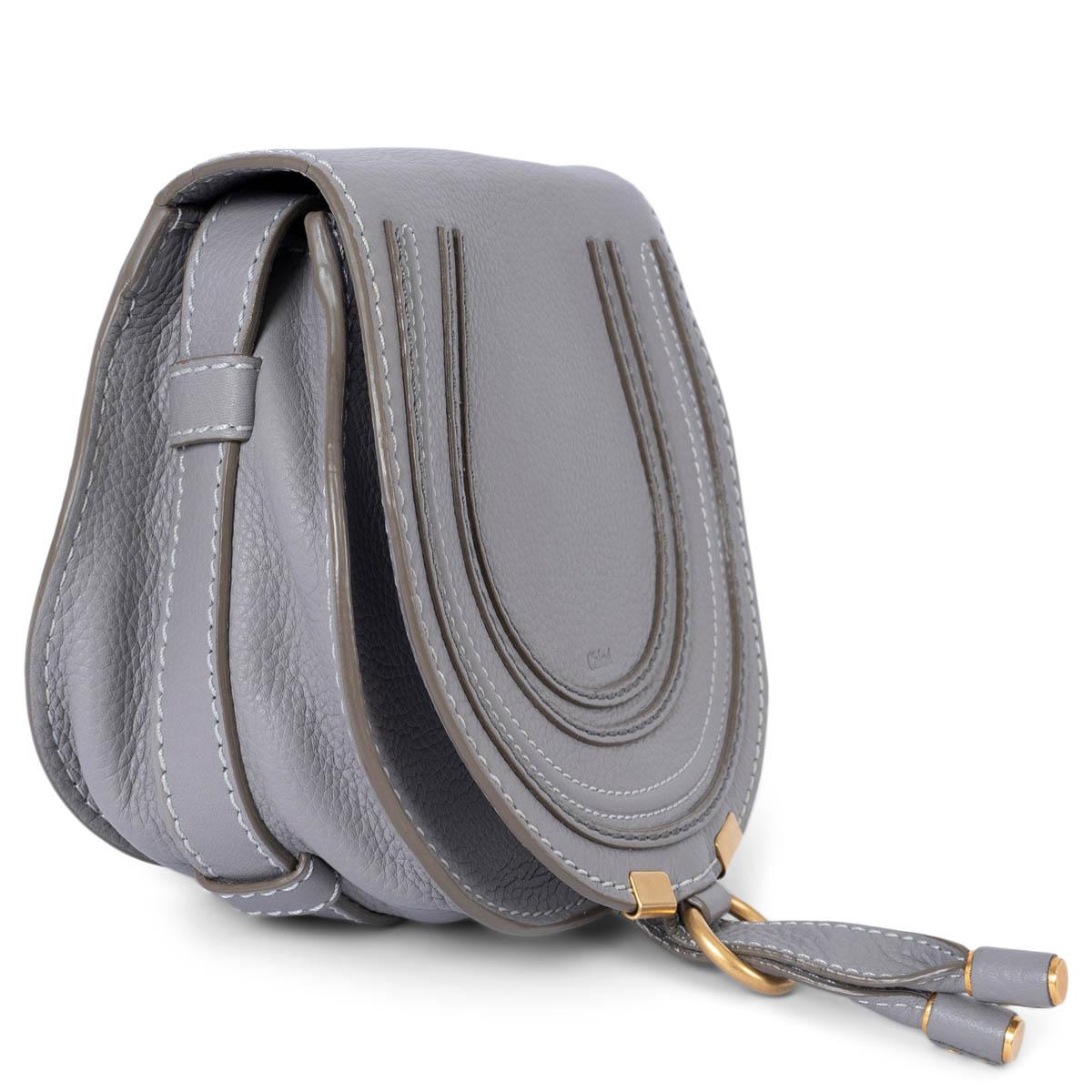 100% authentic Chloé Marcie Mini shoulder bag in grey grained leather. The design features an adjustable shoulder-strap, slot-tab fastening and is lined olive green canvas with an open pocket against the back. Has been carried and is in excellent