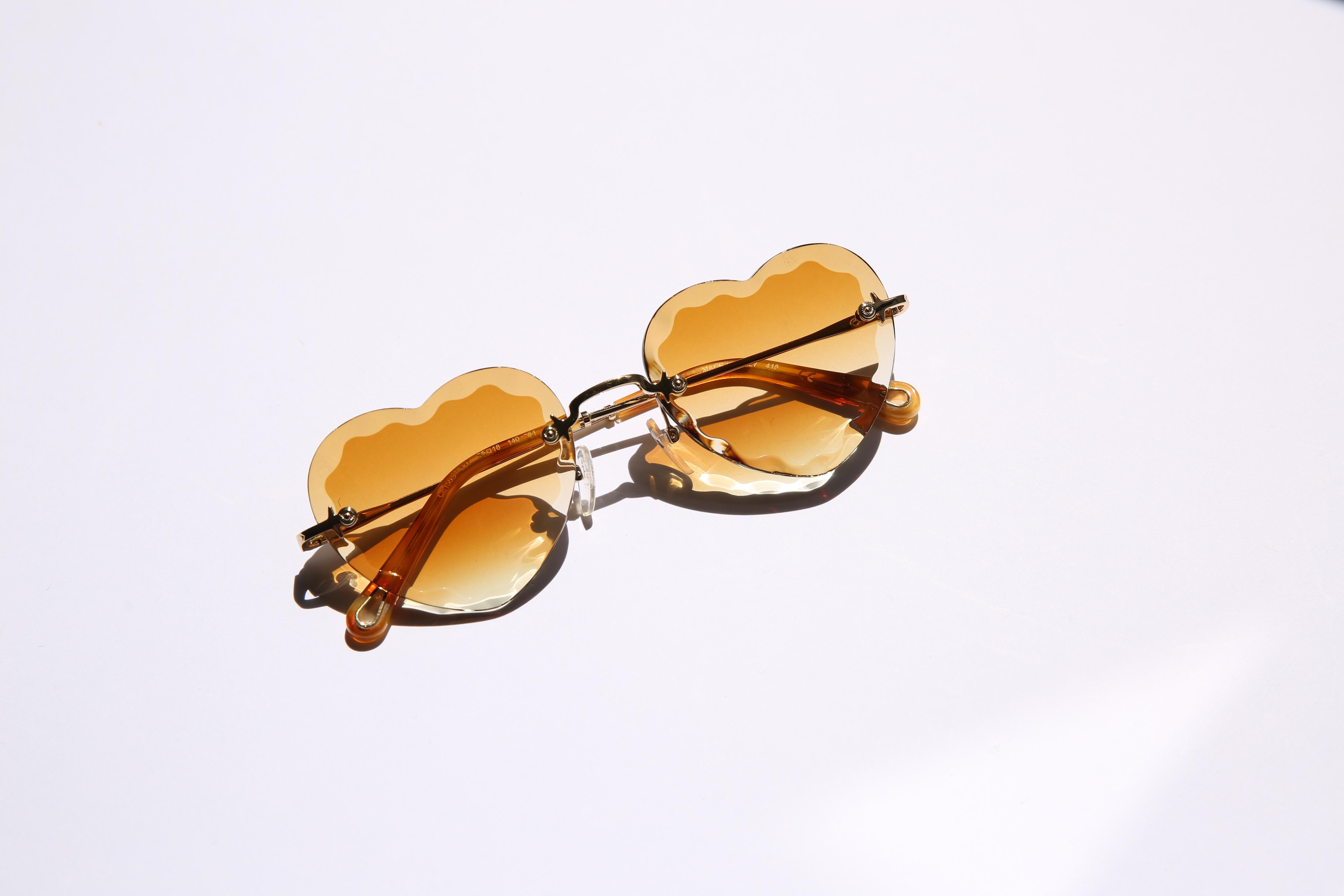 Chloe heart shaped Rosie sunglasses in brown with gold hardware

Unique and feminine with a hint of mischief, the Rosie line is reimagined in a playful heart shape. Distinctive thick bevelled lenses create a strong yet light silhouette in these