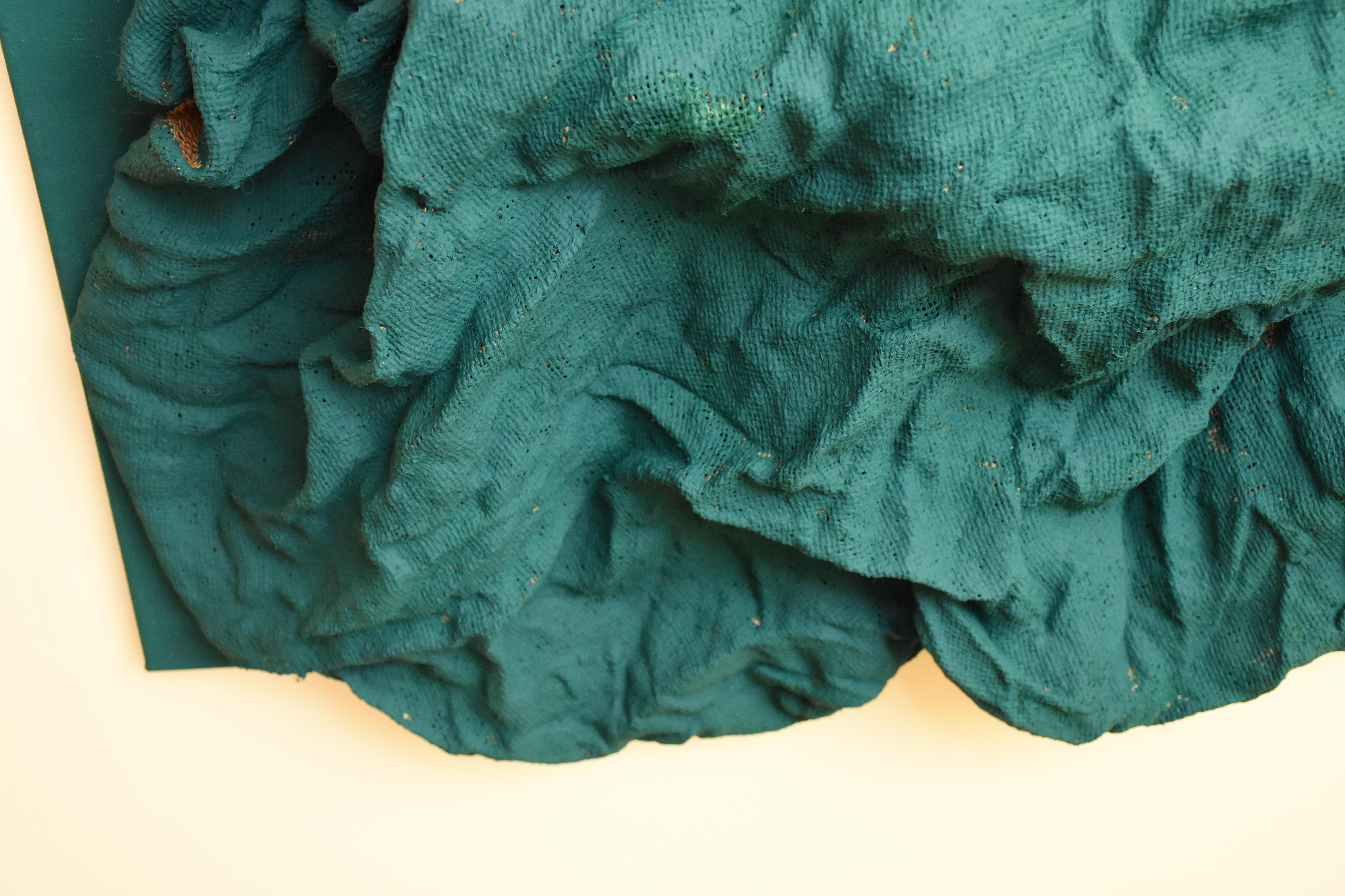 “Emerald Green Folds” is a deep green colored wall sculpture made
with fabric on linen. The elegant folds are steadily built up and add
intricacy to the structure. This creates a dynamic artwork where light
circulates on the surface and shadows are