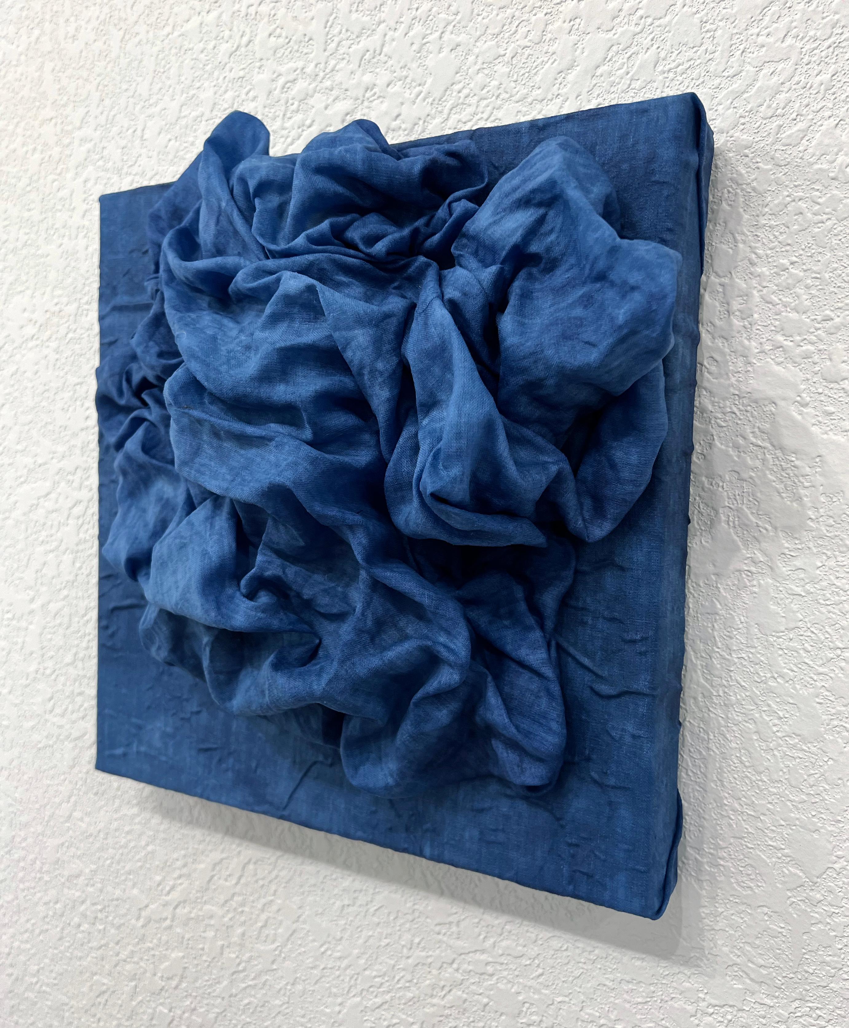 In Indigo 1 lädt uns Chloe Hedden in ein meditatives Feld aus Textur, Bewegung und Farbton ein. Dieses Werk aus der Serie Foldes besteht aus handgefärbtem Leinen in tiefen, dunklen Indigotönen, die wie Strömungen in ruhigen Gewässern über die