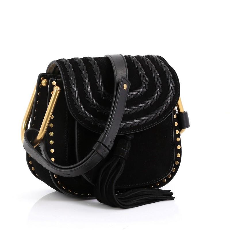 This Chloe Hudson Handbag Whipstitch Suede Mini, crafted from black suede, features an adjustable flat shoulder strap with signature knot, whipstitched trim, front suede tassel, studs embellishment, slip pocket under flap and gold-tone hardware. Its