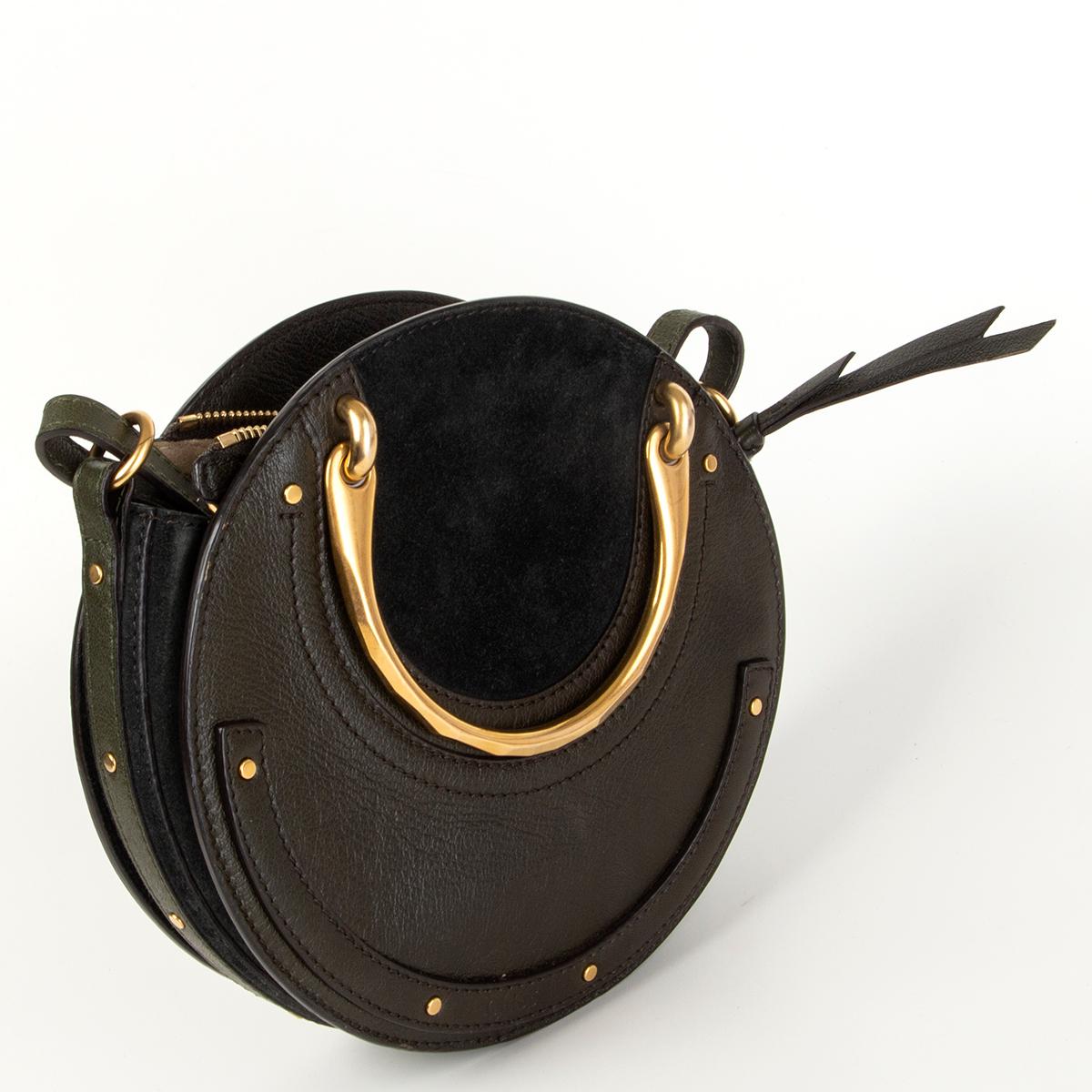 Chloé 'Pixie Small Double Handle' circle shoulder bag in deep forest green paneled calfskin and suede with stud trim. Brassy round tote handles. Removable and adjustable shoulder strap. Flaps cover recessed zip top closure. Embossed logo at bottom
