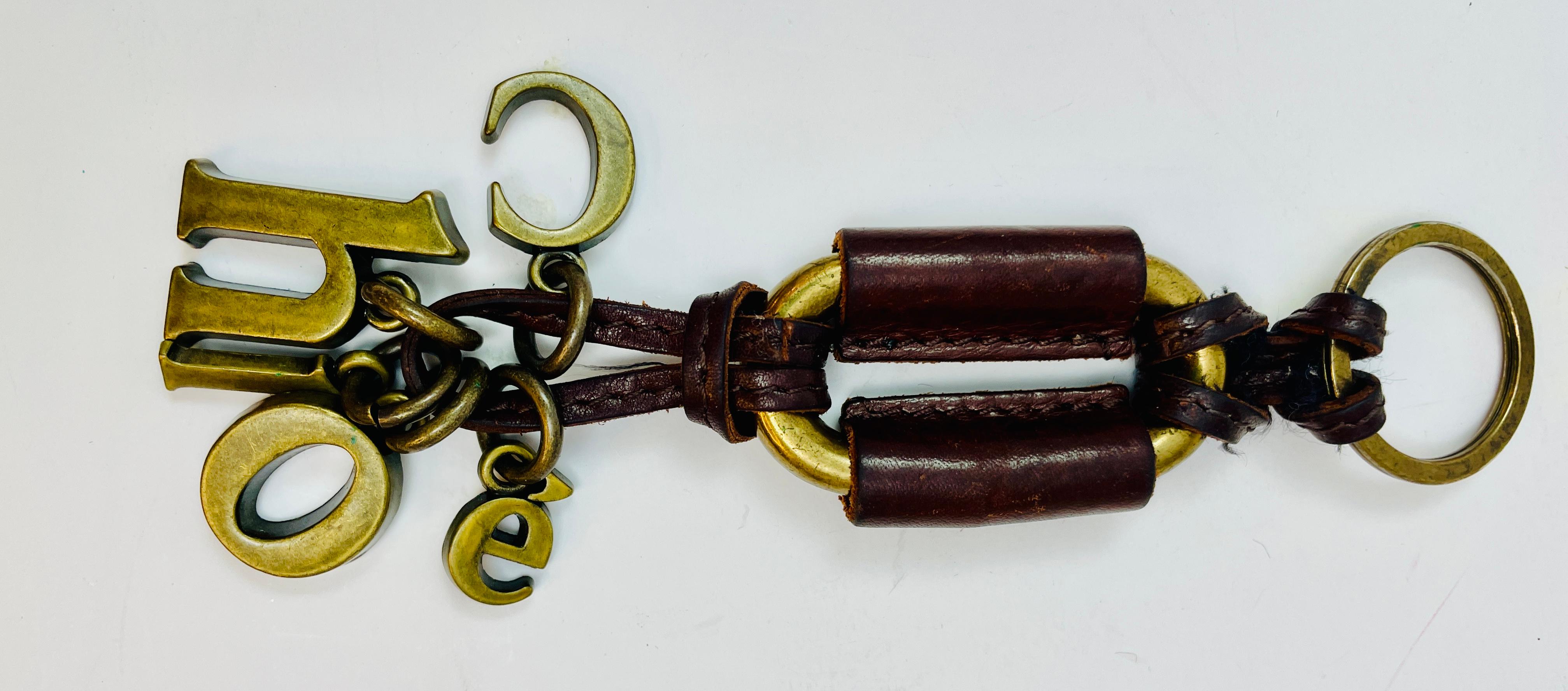 Porte-clés Chloé en cuir brun et métal bronzé huilé.
Bague, cuir et lettre CHLOE en métal attachée au cuir.
6.5 in. Longueur x 1,5 in. Large
