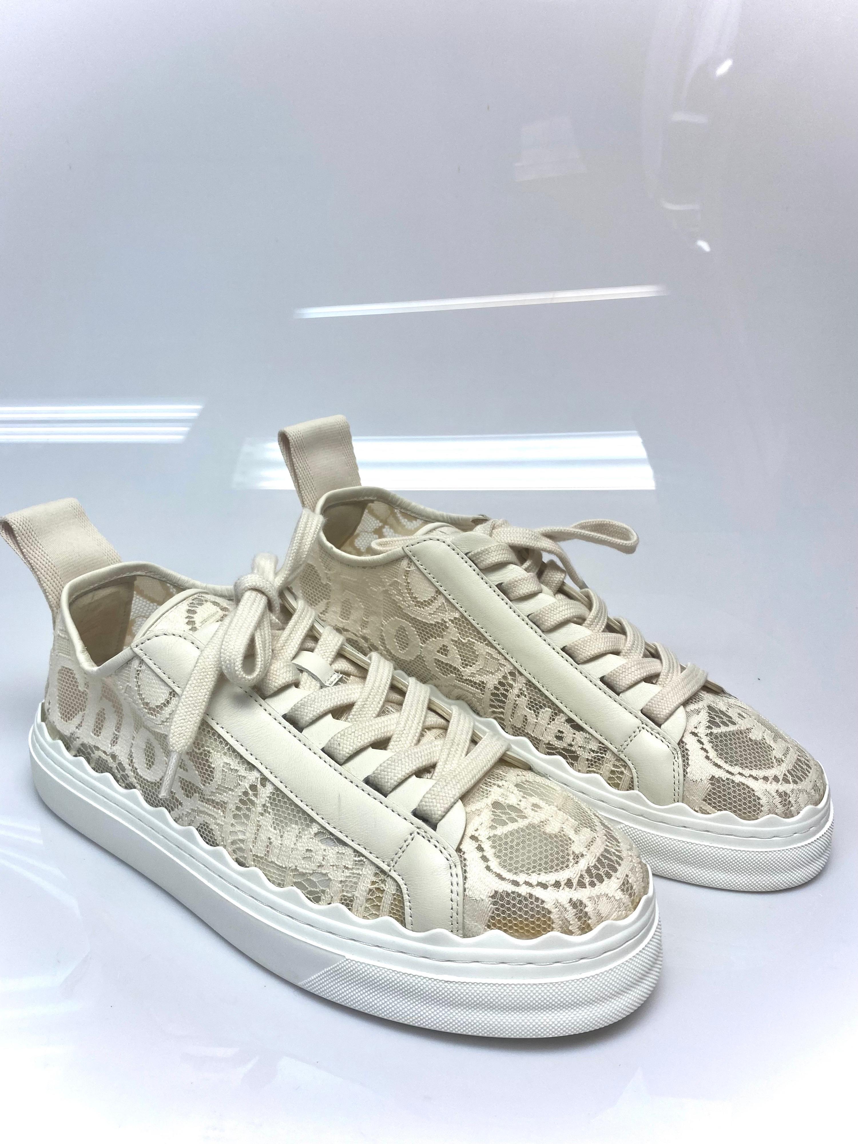 Chloe Lauren Lace Ivory Sneaker Size 39. These stunning Chloe sneakers in Ivory are a must for any wardrobe. Tonal buffed leather trim and embroidered lace logo pattern throughout. Rounded toe. This item is never worn however there is some yellow
