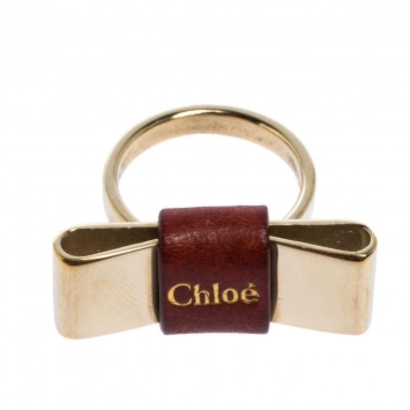 Cette bague bien conçue de Chloé est si jolie que vous adorerez l'avoir au doigt. Cette création en métal doré est ornée d'un nœud en cuir et du nom de la marque. Elle est complète avec les détails du poinçon.