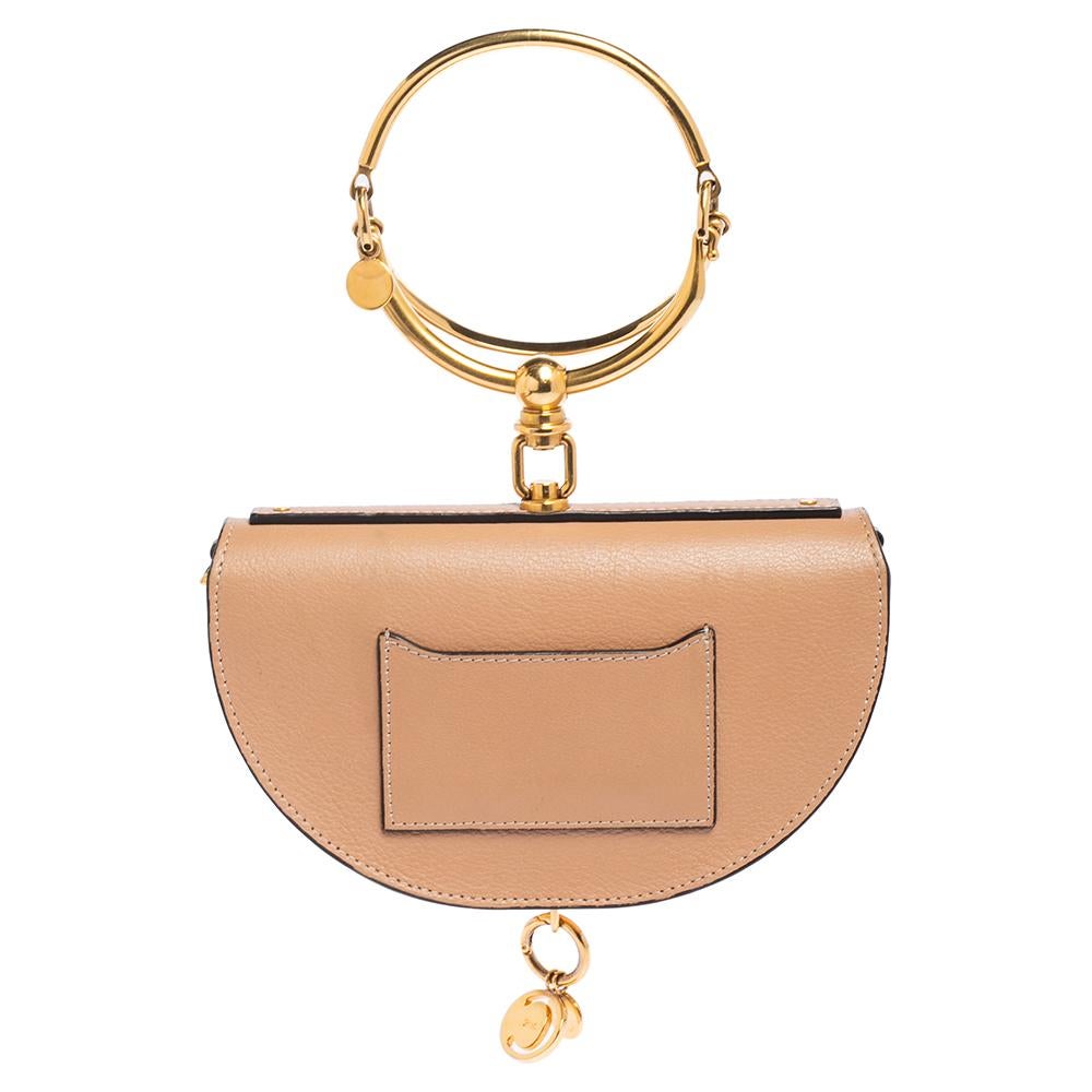 Loved by fashion influencers and celebs, this chic Nile bag by Chloé can become your most favorite bag, thanks to its unique half-moon-like shape and the bracelet handle. It has been crafted from beige leather and styled with a front flap that opens