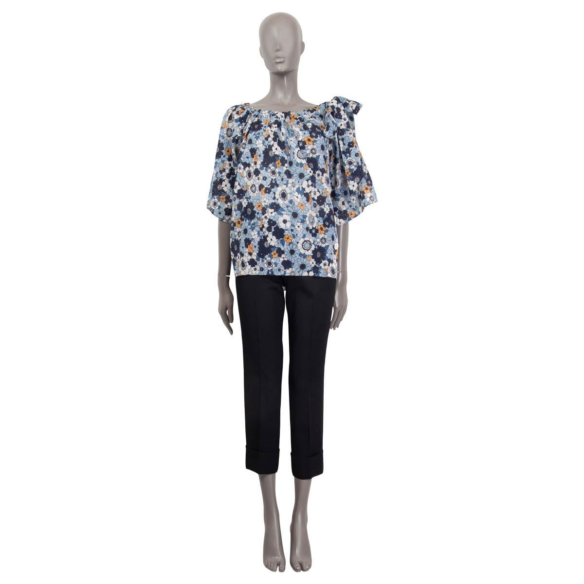 100% authentic Chloé oversized floral print blouse in blue, navy blue, orange and off-white cotton (100%). Features short raglan sleeve (sleeve measurements taken from the neck) and a gauze bow on the shoulder. Opens with four white buttons on both