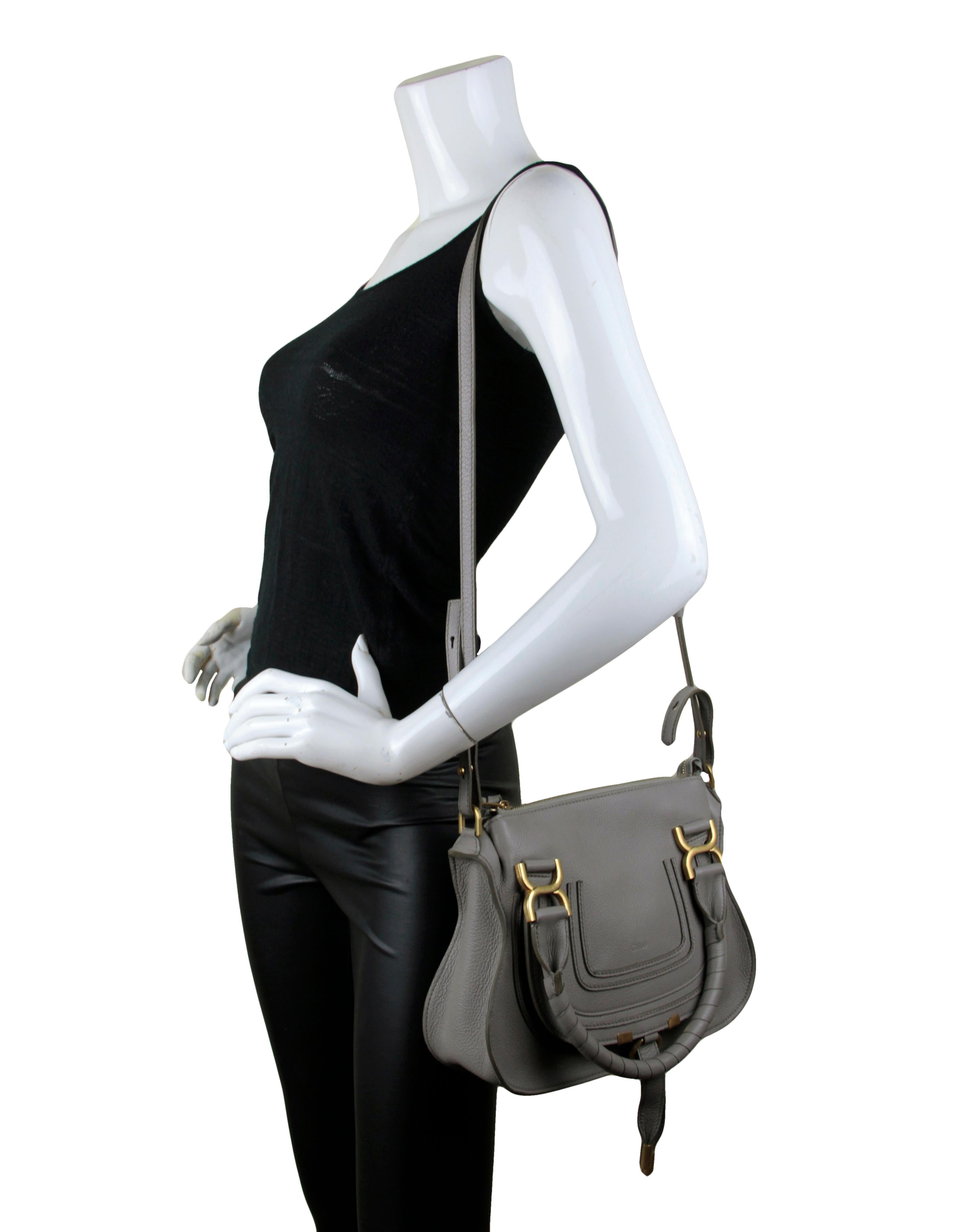 Chloe Cashmere Grey Leather Small Marcie Bag

Made In: Italy
Color: Grey
Hardware: Goldtone
Materials: Grained calfskin leather
Lining: Cotton lining
Closure/Opening: Zip top
Exterior Pockets: Front slit pocket under flap
Interior Pockets: One zip