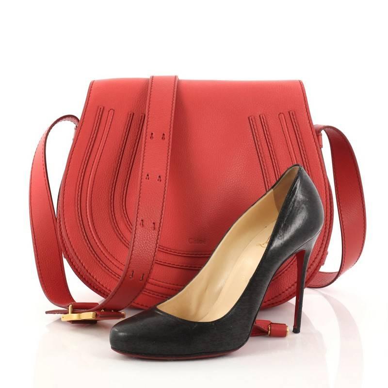 This authentic Chloe Marcie Crossbody Bag Leather Medium showcases the brand's popular horseshoe design. Crafted from red leather, this saddle-style bag features stitched horseshoe detail on the front, stamped Chloe label, bow-shaped buckles,