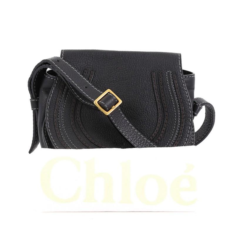 This Chloe Marcie Crossbody Bag Leather Mini, crafted from black leather, features stitched horseshoe detail on the front, adjustable leather strap, and gold-tone hardware. Its flap opens to a green fabric interior with slip pocket. 

Estimated