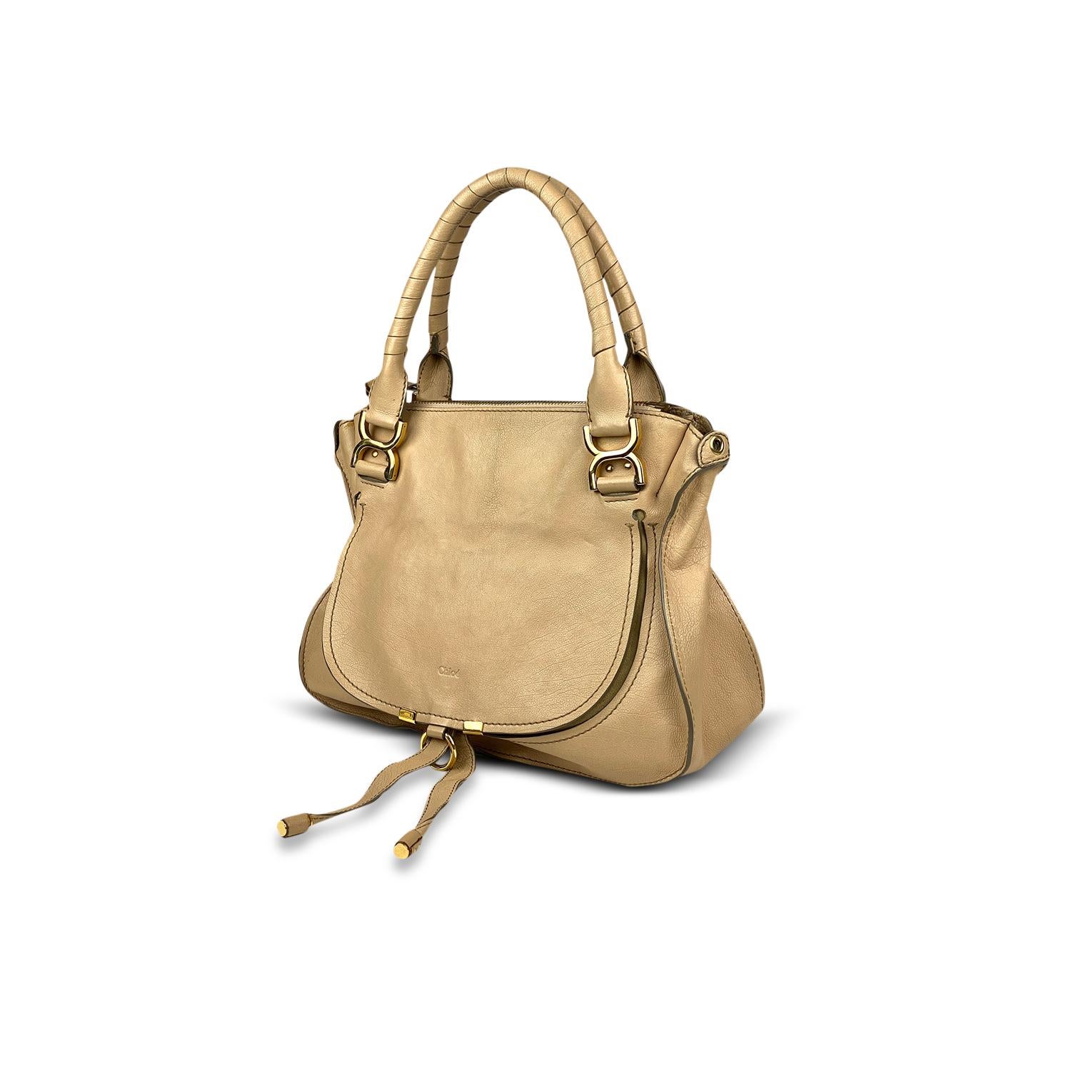 Beige leather Chloé Marcie shoulder bag with

- Gold-tone hardware
- Dual rolled top handles
- Contrast stitching throughout
- Single slit pocket at flap underside with pull-through closure, tonal interior lining, single zip pocket at interior wall,
