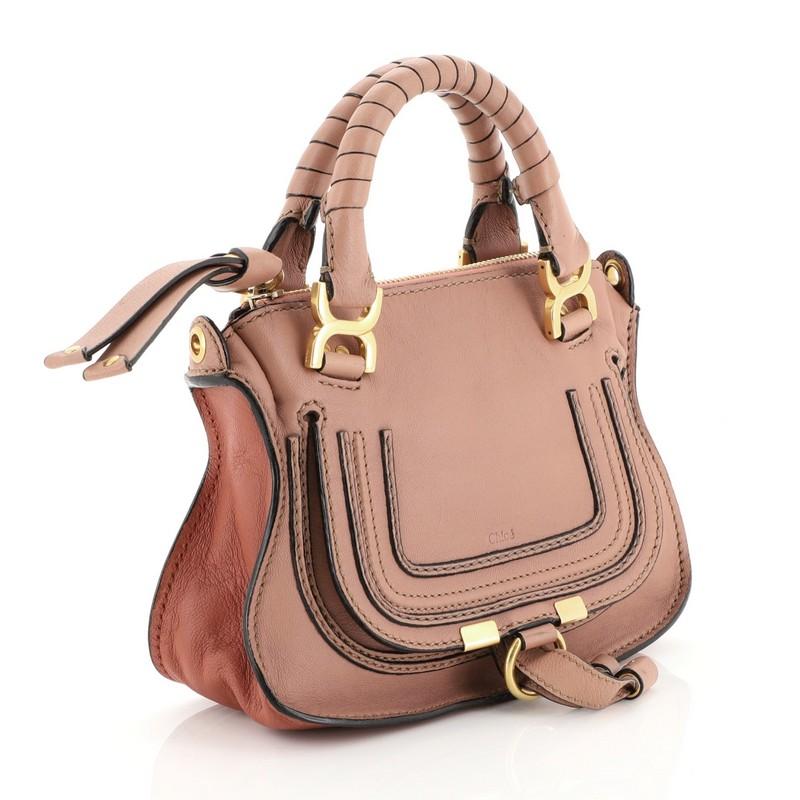 This Chloe Marcie Satchel Leather Baby, crafted from pink leather, features dual wrapped top handles, horseshoe stitched front flap with tie closure, and gold-tone hardware. Its top zip closure opens to a neutral fabric interior with side slip