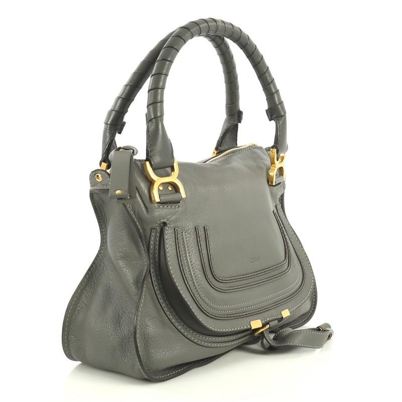 This Chloe Marcie Satchel Leather Medium, crafted in gray leather, features wrapped leather handles, horseshoe stitched front flap, and gold-tone hardware. Its top zip closure opens to a green fabric interior with zip and slip pockets. 

Estimated