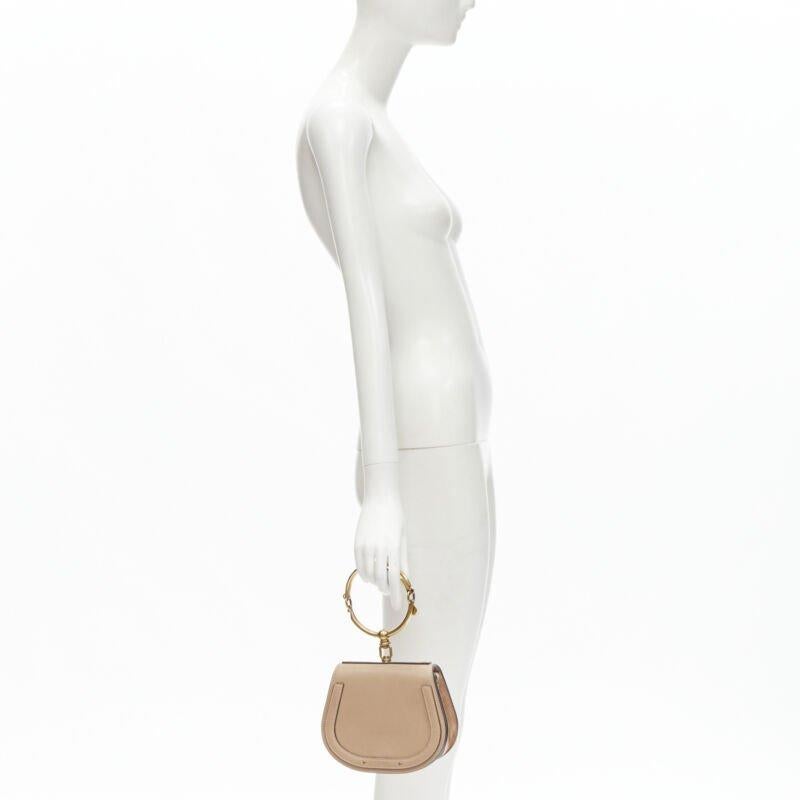 CHLOE Medium Nile gold bangle bracelet handle taupe leather saddle bag
Reference: JACG/A00010
Brand: Chloe
Model: Nile bag
Material: Leather, Metal
Color: Beige, Gold
Pattern: Solid
Closure: Magnet
Lining:  Suede
Extra Details: Antique gold-tone