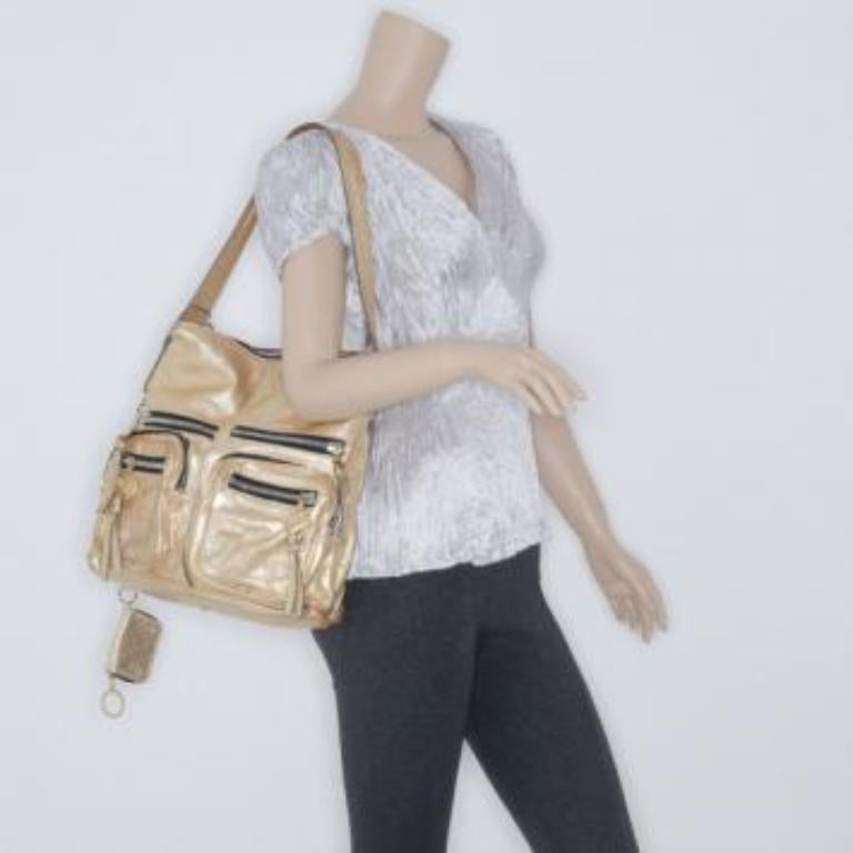 Questa borsa a tracolla Metallic Gold di Chloe è pronta ad accompagnarti ovunque! L'esterno è realizzato in pelle scintillante color oro metallizzato e la borsa è dotata di due scomparti anteriori, due tasche piatte con cerniera, uno scomparto