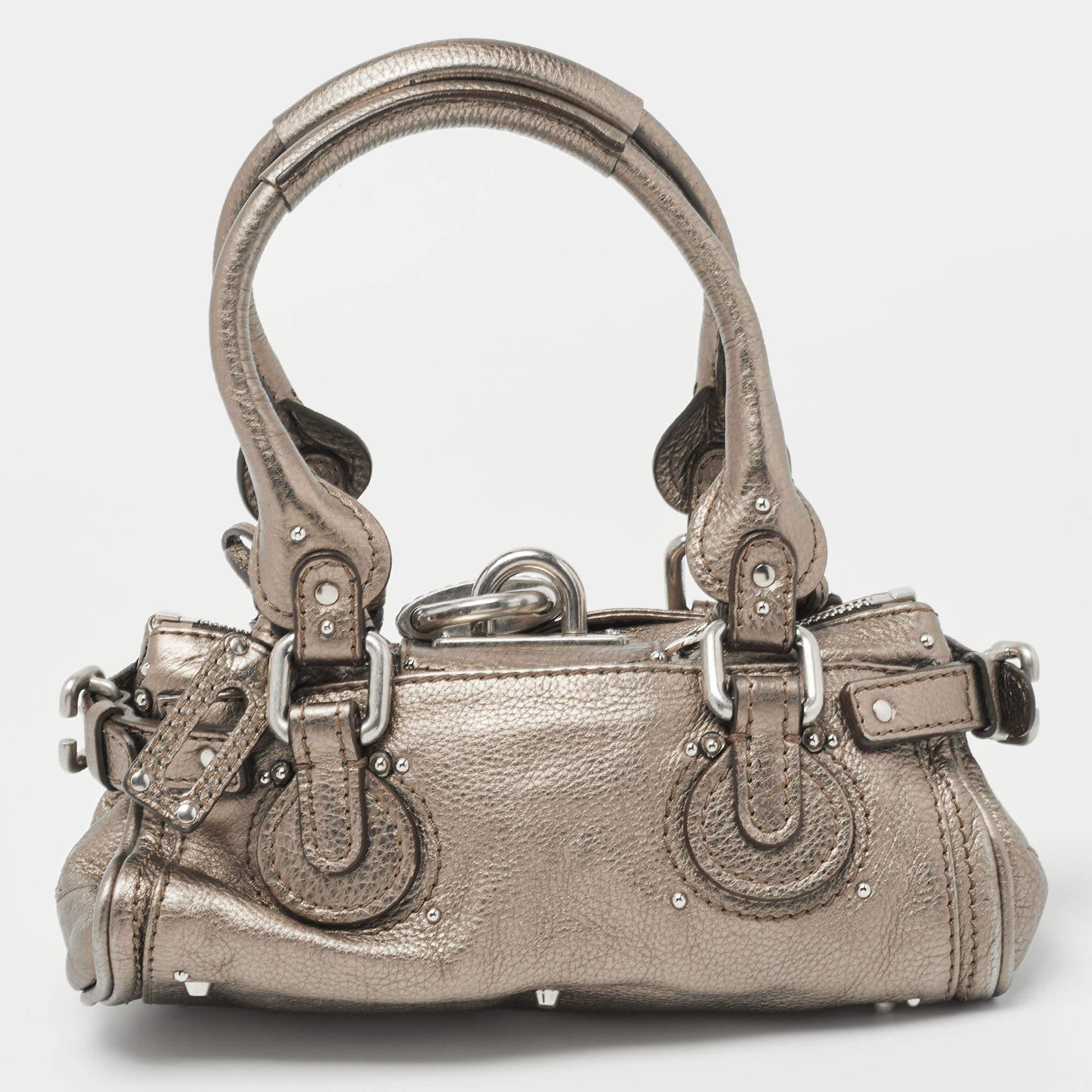 This Chloe Paddington satchel is built to assist your impeccable style on all days. Silver-tone hardware with a chunky lock on the front easily attracts all the attention. The metallic leather has an interesting texture while the fabric interior is