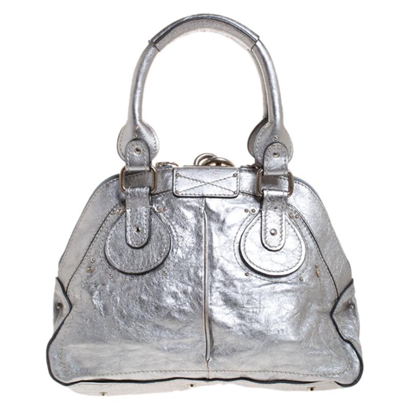 Chole’s Paddington satchel is glamorous indeed with a retro vibe. The chunky lock on the front and the dangling chords with the keys grab all the attention. It is crafted from metallic silver leather, has a fabric interior that is quite roomy and