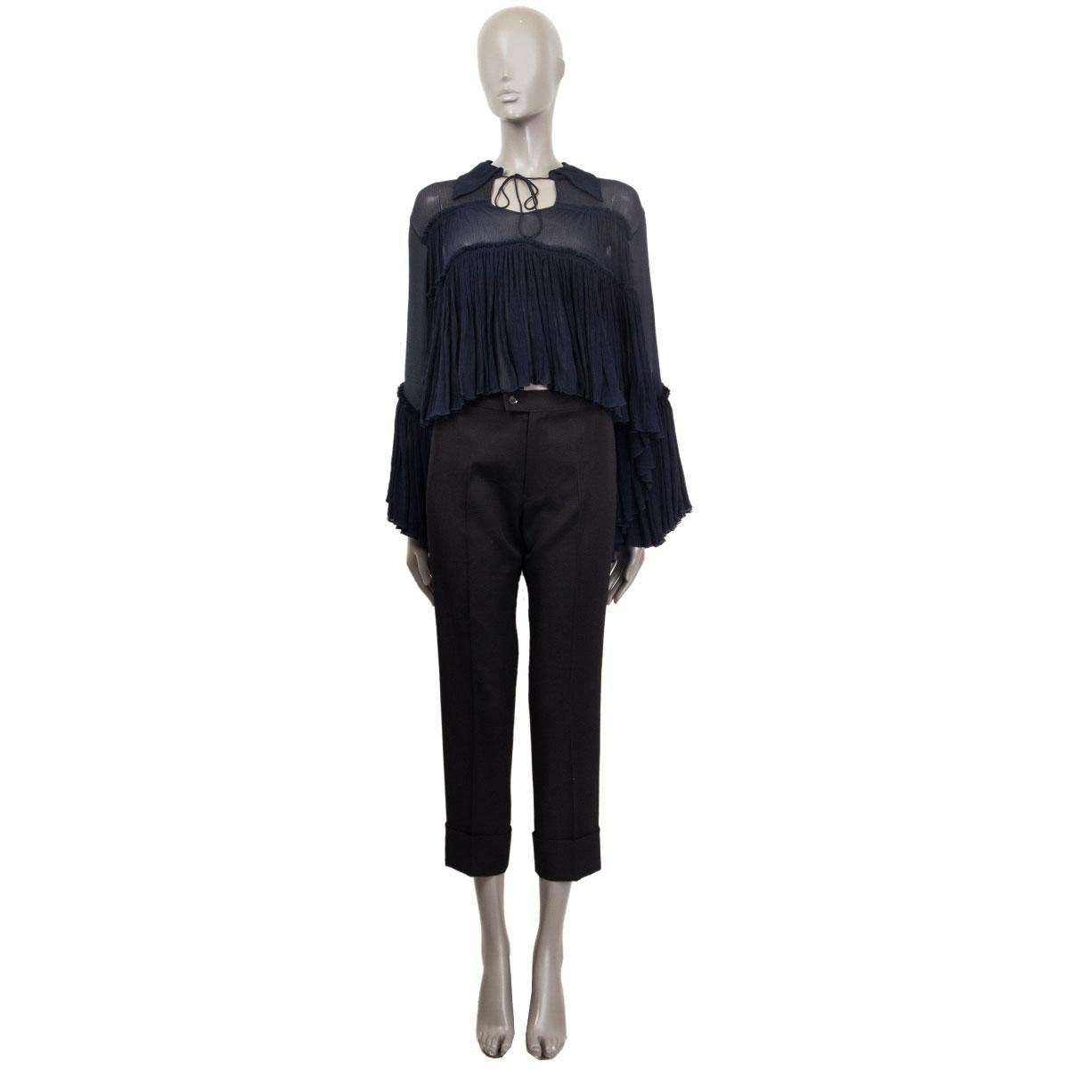 100% authentic Chloé oversized cropped poncho-sleeve blouse in sheer midnight blue silk (100% - Missing Tag) with point collar and tie accent at front. Blouse features ruffle accents throughout. Has been worn and is in excellent condition.