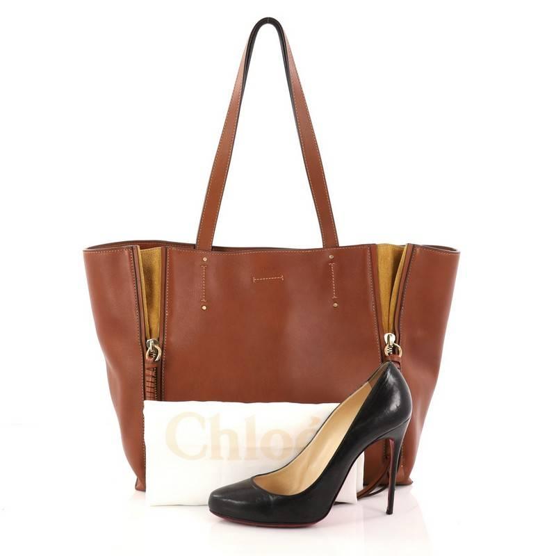 This authentic Chloe Milo Shopping Tote Leather Medium is a perfect bag for everyday excursions that are fresh and contemporary for the new season. Crafted from brown leather, this stylish bag features dual flat top handles, contrast suede gussets