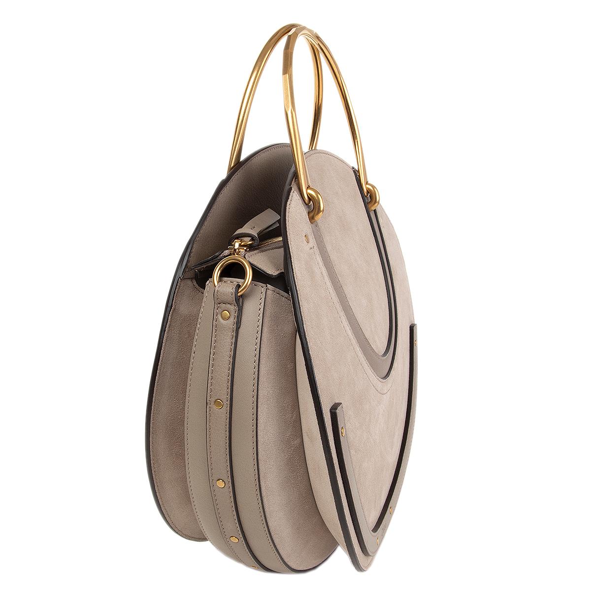 Chloé 'Pixie Medium Double Handle' circle shoulder bag in Motty grey paneled calfskin and suede with stud trim. Brassy round tote handles. Removable and adjustable shoulder strap. Flaps cover recessed zip top closure. Embossed logo at bottom center.