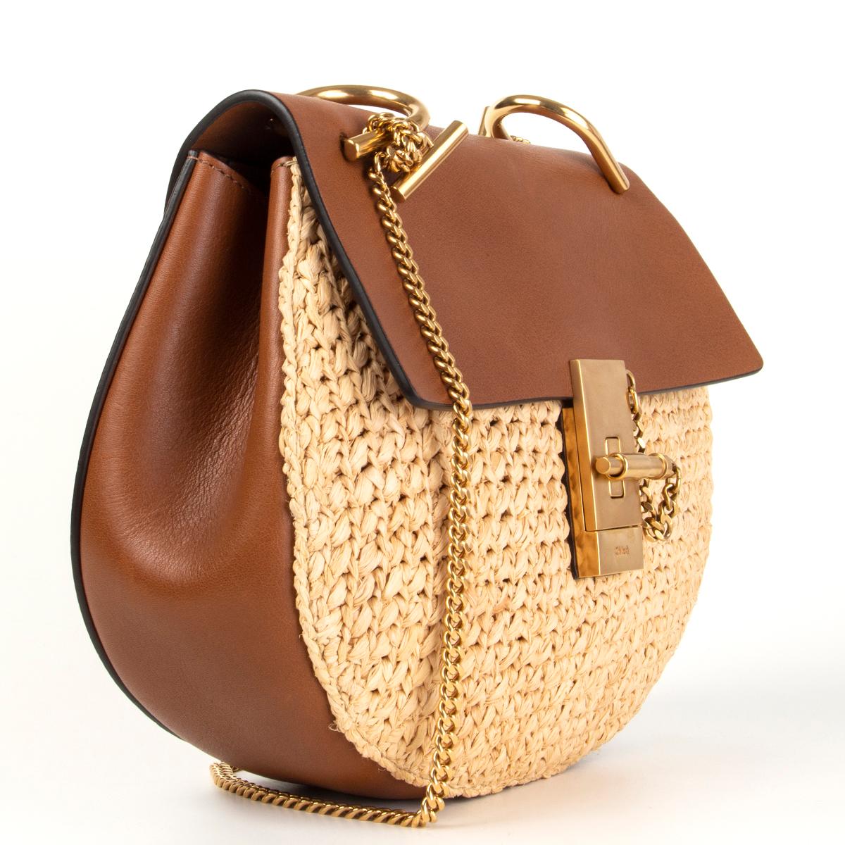 Chloé 'Small Drew' shouldr bag in beige raffia and tan calfskin. Opens with flap and turn-lock in gold-tone metal featuring chain shoulder strap. Lined in tan calfskin with one open pocket against the back. Has been carried once with a small scratch