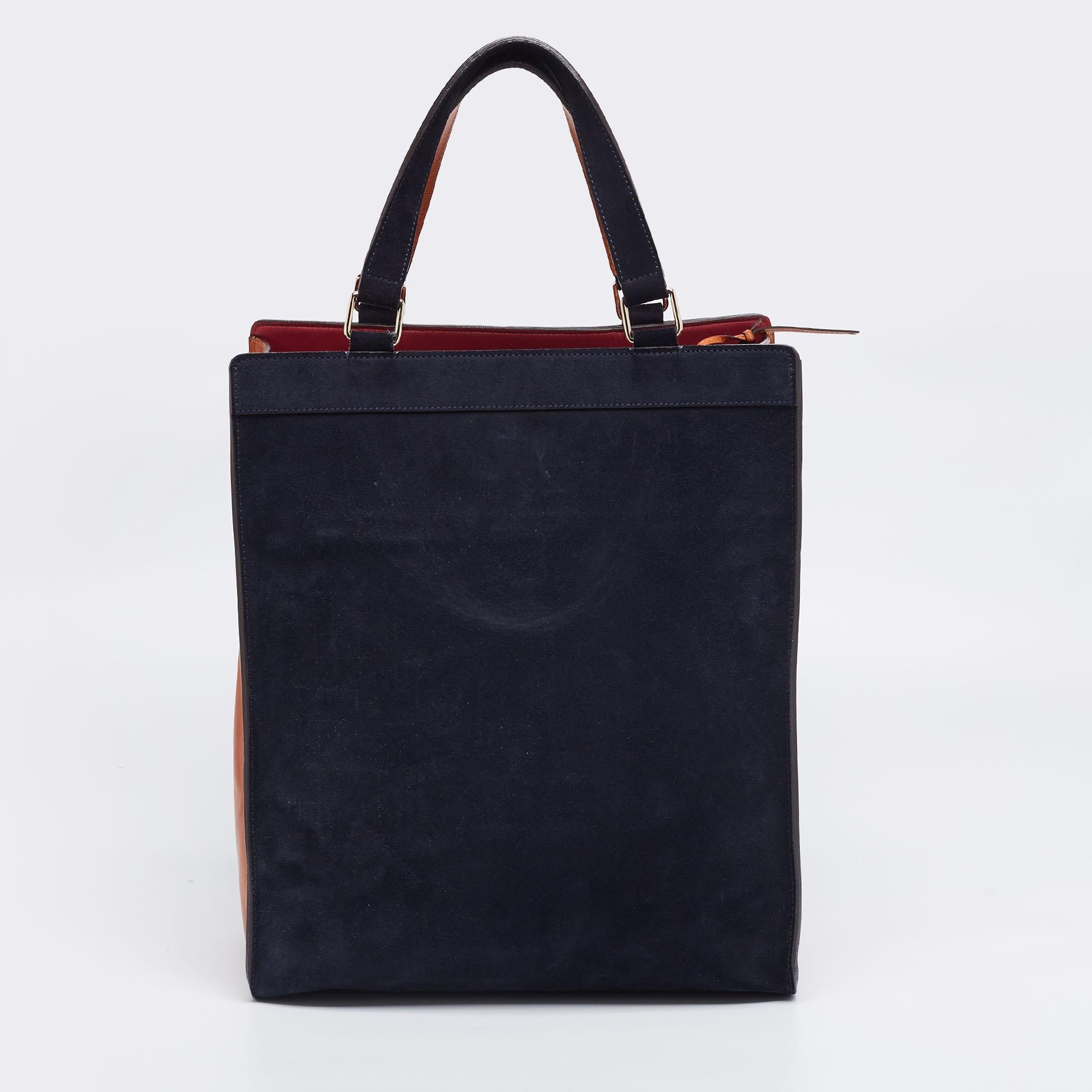 This pre-owned Chloe tote will be a lovely addition to your closet. It has been crafted from navy blue suede as well as tan leather and added with gold-tone hardware, two top handles, a front zip pocket, and a leather-lined interior.

Includes: