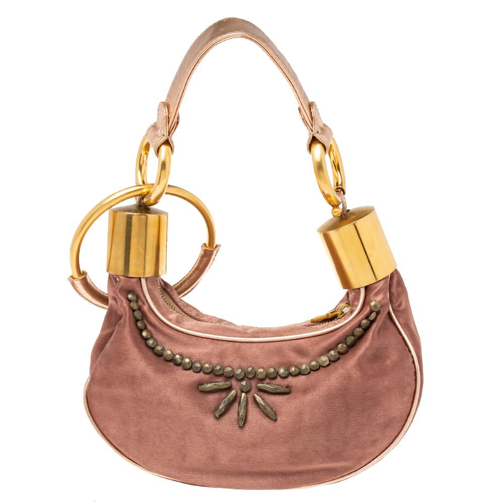 Give your totes and hobos a rest and opt for this accessory when you're heading out for the day or evening. The fabric bag is petite and grand in design. It is held by gold-tone rings and covered with embellishments on the exterior. Talk about a