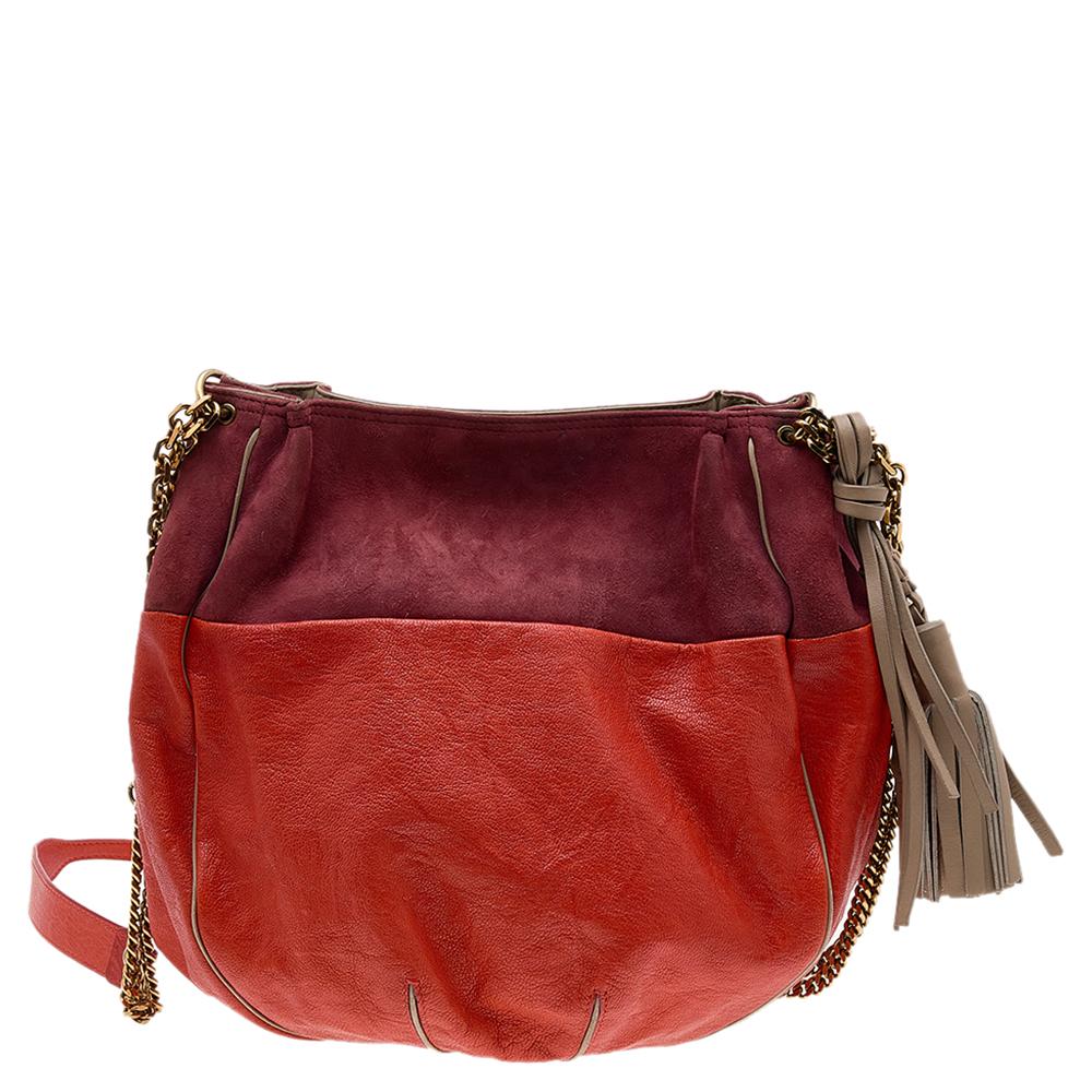 Chloe brings to your closet this vibrant orange and brown hobo that is perfect for summer outings! Crafted from leather and suede, it has a shoulder strap for ease of carrying. Gold-tone hardware and tassel details provide the finishing touches to