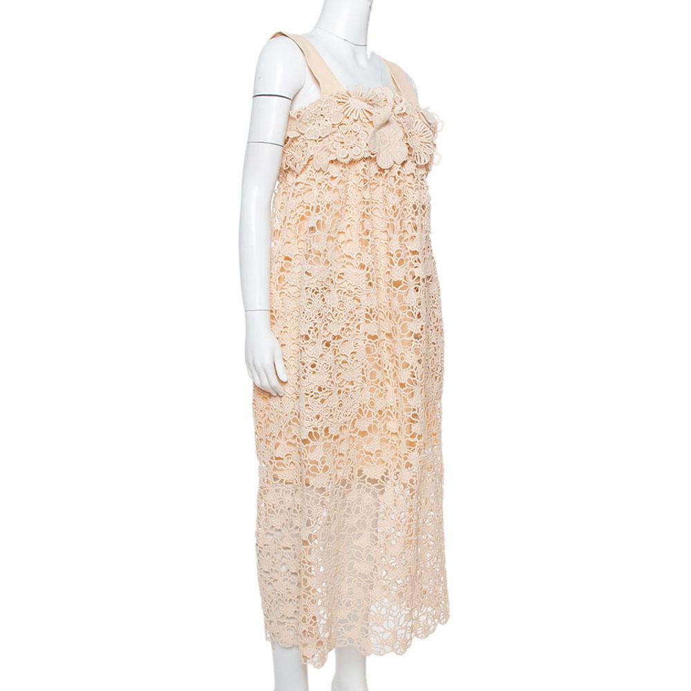 A delicate lace exterior with floral motifs meets a soft pale orange hue to characterize this feminine midi dress by Chloe. It has a sleeveless silhouette, a flattering empire waistline, and a comfortable fit. It is perfect for summer outings. Pair