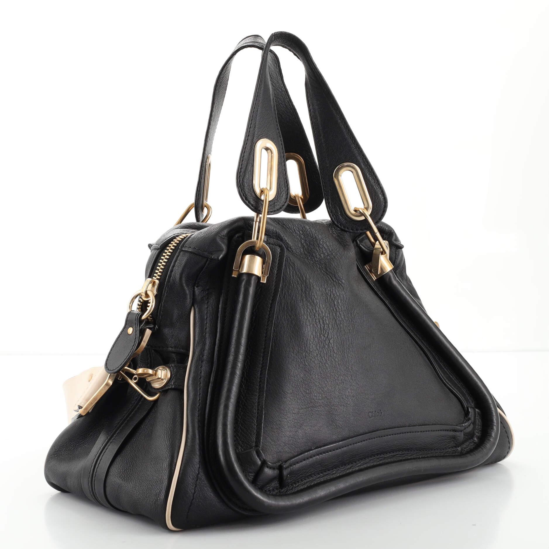 Condition: Fair. Moderate creasing, wear and scuffs on exterior, handles and strap, heavy cracking and peeling on handle wax edges, cracking on strap and zipper pull wax edges. Wear and darkening in interior, scratches, discoloration and tarnish on