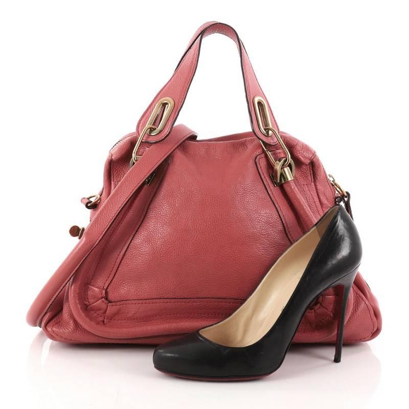 This authentic Chloe Paraty Top Handle Bag Leather Medium mixes everyday style and functionality perfect for the modern woman. Crafted from red leather, this versatile bag features dual flat handles, piped trim details, side twist locks, and
