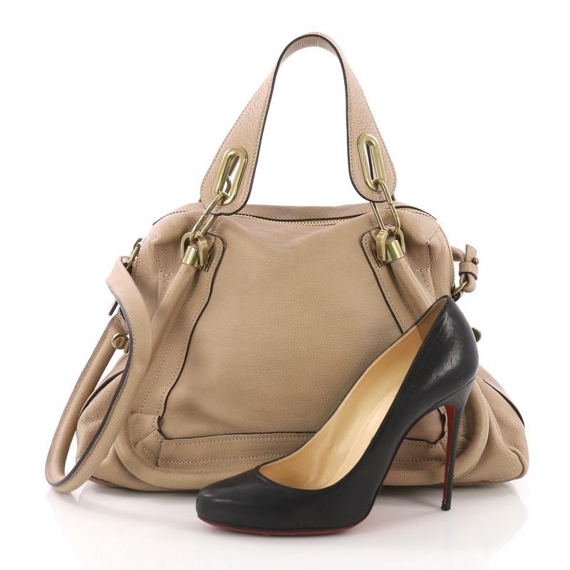 This Chloe Paraty Top Handle Bag Leather Medium, crafted in beige leather, features dual flat handles, piped trim details, side twist locks, and gold-tone hardware. Its top zip closure opens to a black fabric interior with side zip and slip pockets.