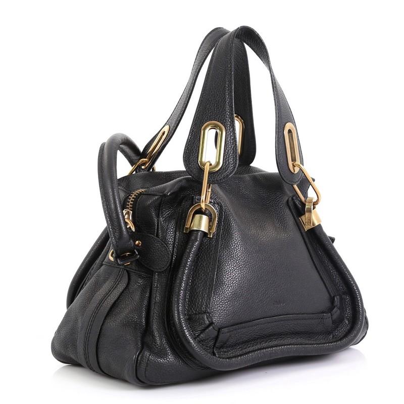 This Chloe Paraty Top Handle Bag Leather Small, crafted in black leather, features dual flat leather handles, piped trim details, and aged gold-tone hardware. Its top zip closure opens to a black fabric interior with zip pocket. 

Estimated Retail