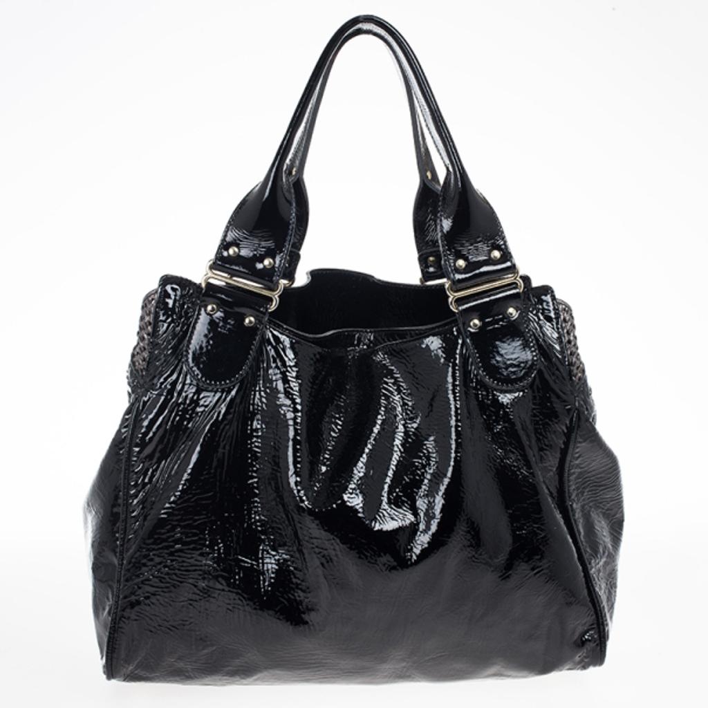 This Chloe Ada bag is ideal for everyday use. It’s crafted from wrinkled patent leather. It features two flat handles, metallic mesh insets, side pockets, a front zipper pocket and a detachable shoulder strap. The interior is lined with canvas and