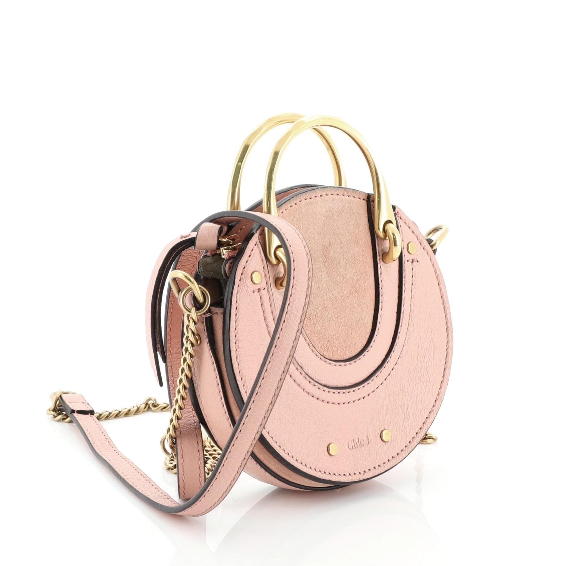 This Chloe Pixie Crossbody Bag Leather with Suede Mini, crafted in pink leather with suede, features a top handle, chain link shoulder strap, and aged gold-tone hardware. Its zip closure opens to a neutral suede interior with two separate
