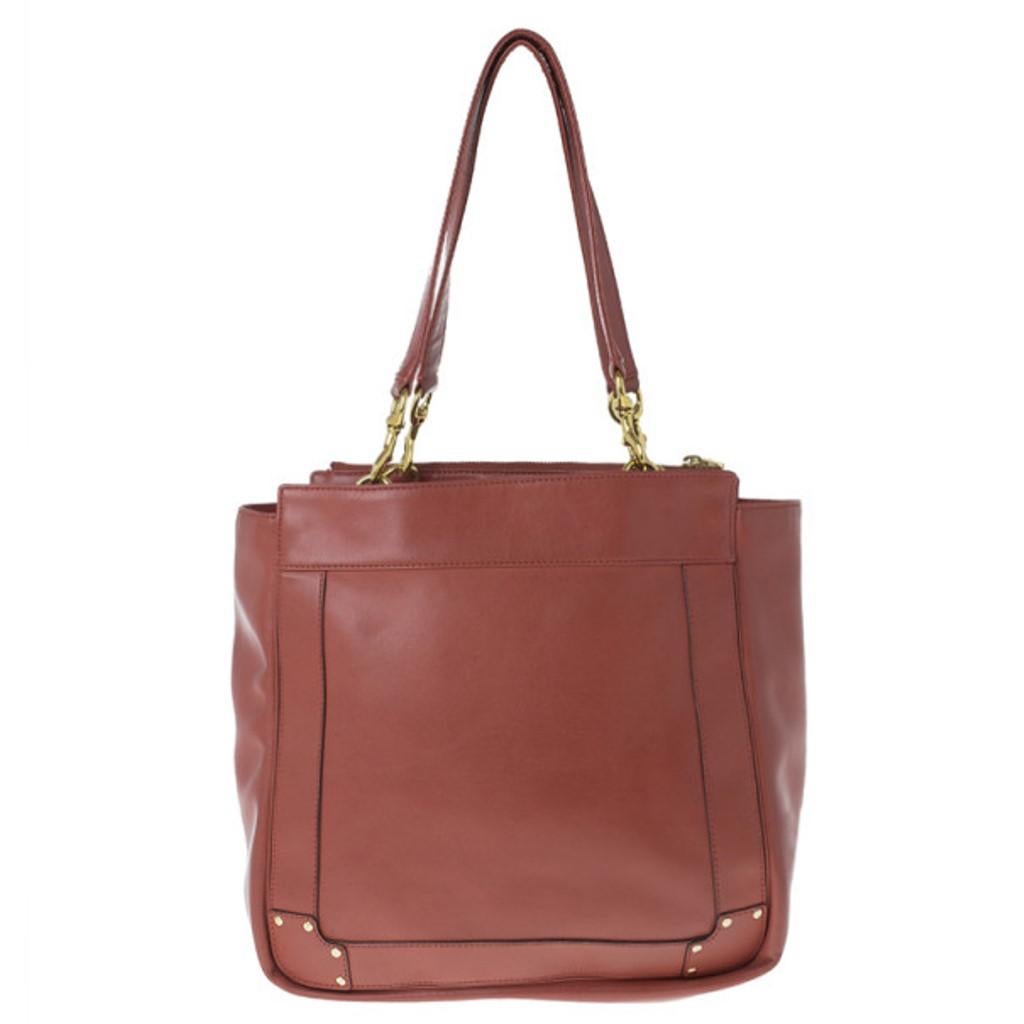 Show your style during your shopping sprees with this ideal Chloe tote. Made from leather, its red color is coupled with a leather handle and golden eyelets. Lined with canvas, it features two patched pockets and a wide space to fit all your