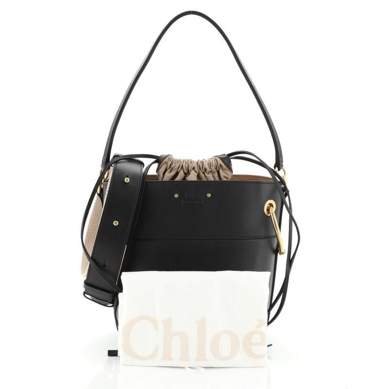 This Chloe Roy Bucket Bag Leather Small, crafted in black leather, features a leather shoulder strap, oversized rings and matte gold-tone hardware. It opens to a neutral fabric interior with zip pocket. 

Estimated Retail Price: $1,800
Condition: